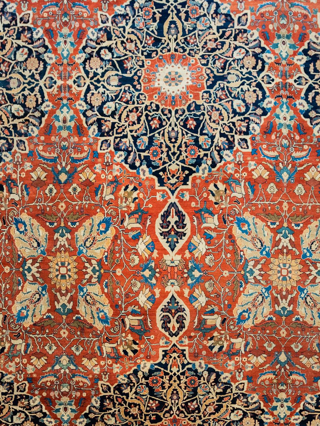 In classic and vibrant shades of bright red, cream, indigo, and black wool, this multi-colored Farahan carpet measures 12’3” x 17”, and was woven circa 1880. Constructed with a traditional Persian weave on a cotton foundation, this carpet’s pile