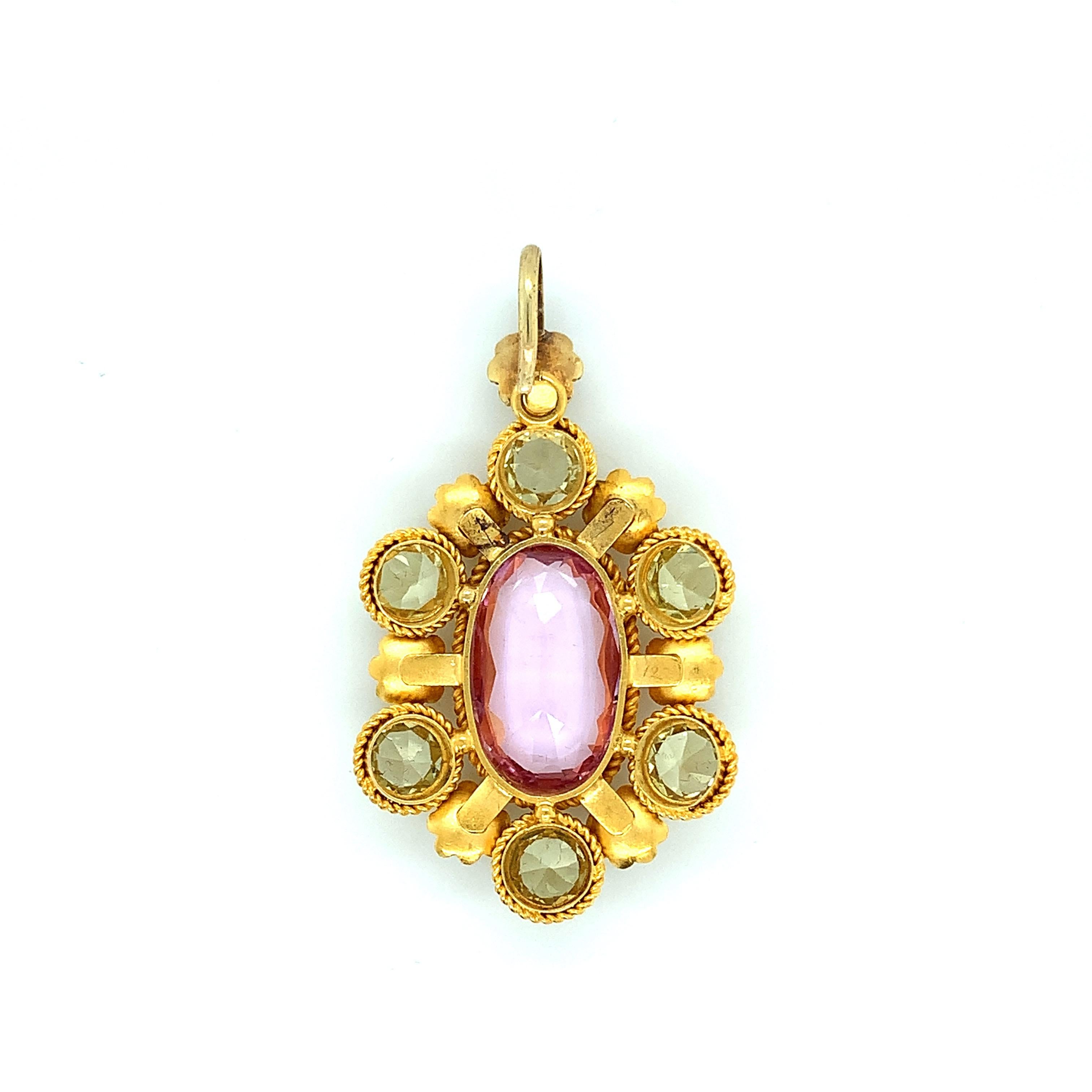 An 18 karat yellow gold antique pendant from the 1880s. At the center is a precious topaz weighing approximately 10 carats. Surrounding this center are six quartz stones weighing approximately 3 carats as well as seven small pearls. Total weight: