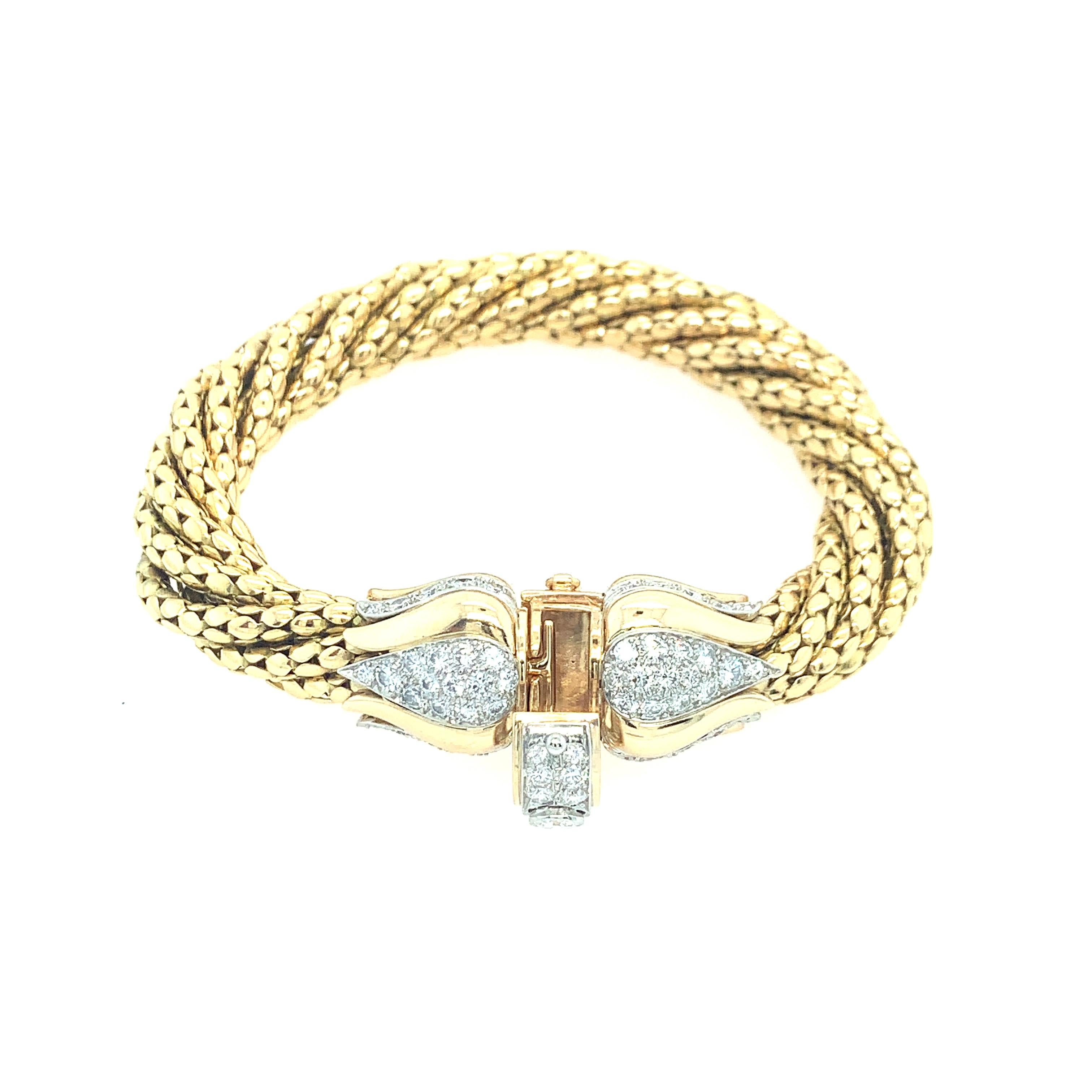 A classic 18K yellow gold exceptional piece featuring (7) seven link chains intertwined creating a sophisticated multirow bracelet. Twisted gold wraps elegantly around the wrist, maintaining a solid weight, yet comfortable for everyday wear. At each
