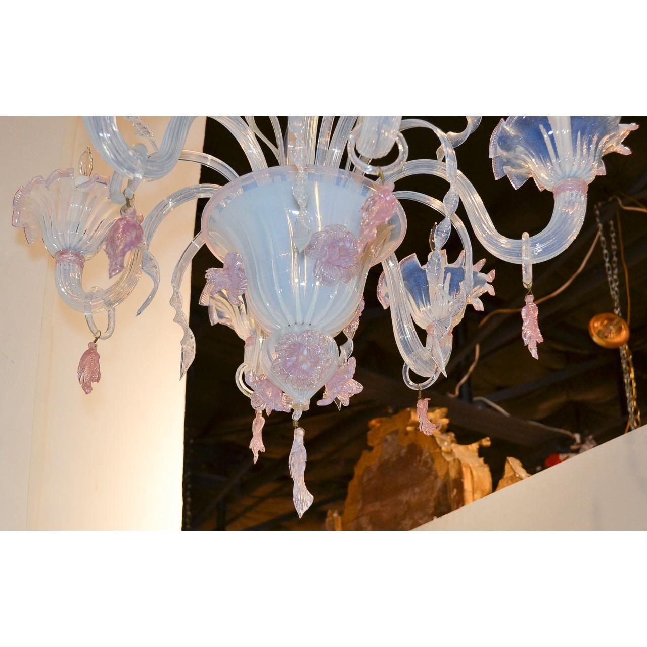 Uniquely designed antique Italian Murano blown glass opalescent chandelier in hues of pale blue and pink. The shaped stem with blossoming flowers and birds depicted in relief and enhanced with long slender leaves. Surmounted by wonderfully scrolled