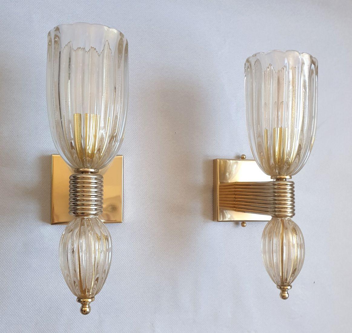 Pair of Mid-Century Modern Murano glass and brass sconces, Italy, attributed to Barovier and Toso, circa 1960.
The antique sconces are made of hand-blown Murano glass, clear with gold flakes, with a beautiful and quality thickness, making the glass
