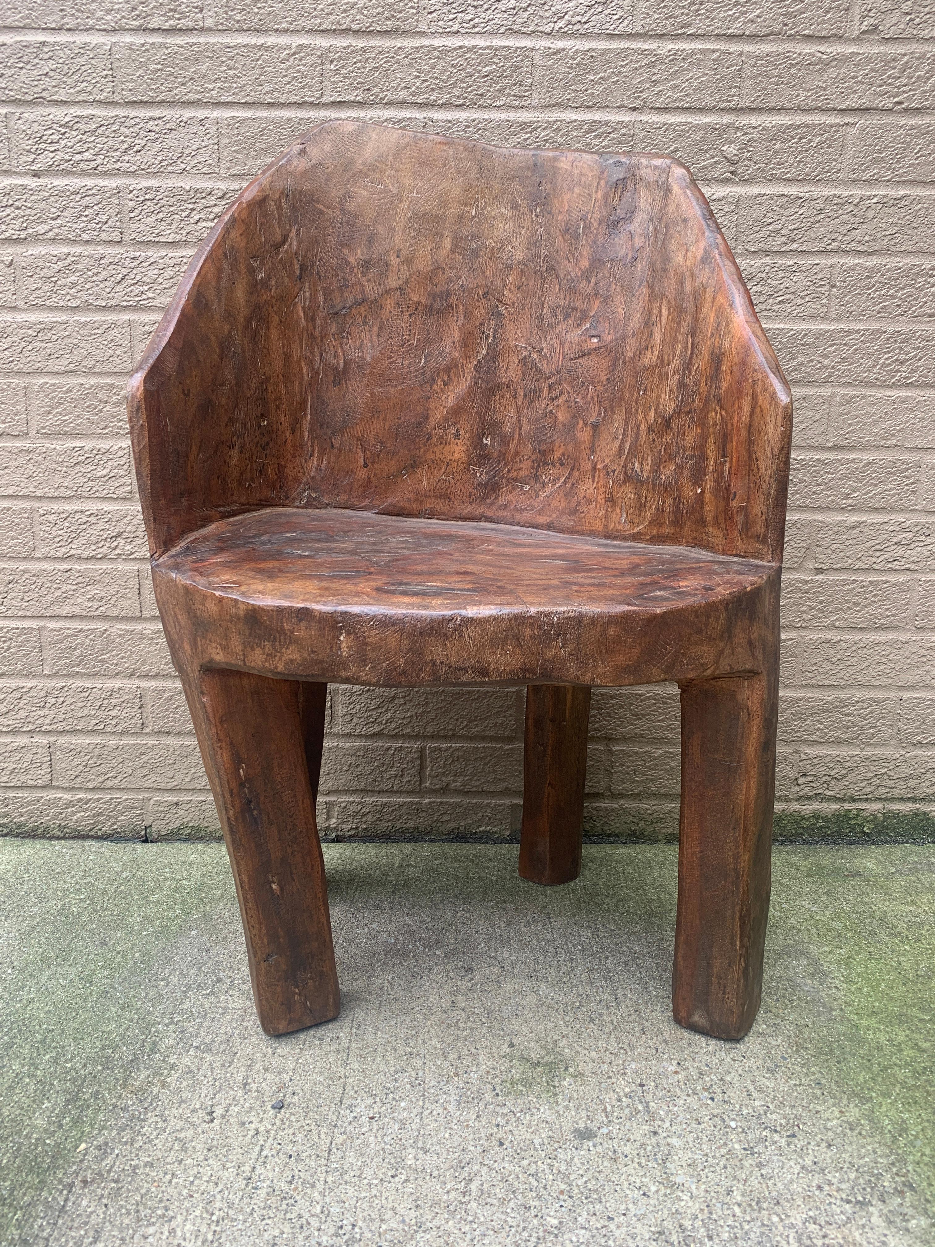 A stunning antique organic hand-carved tree stump chair carved from one piece of wood by the Naga people of India. This sculptural piece would be at home in a modern or traditional interior. Its rustic form and evidence of cultural heritage