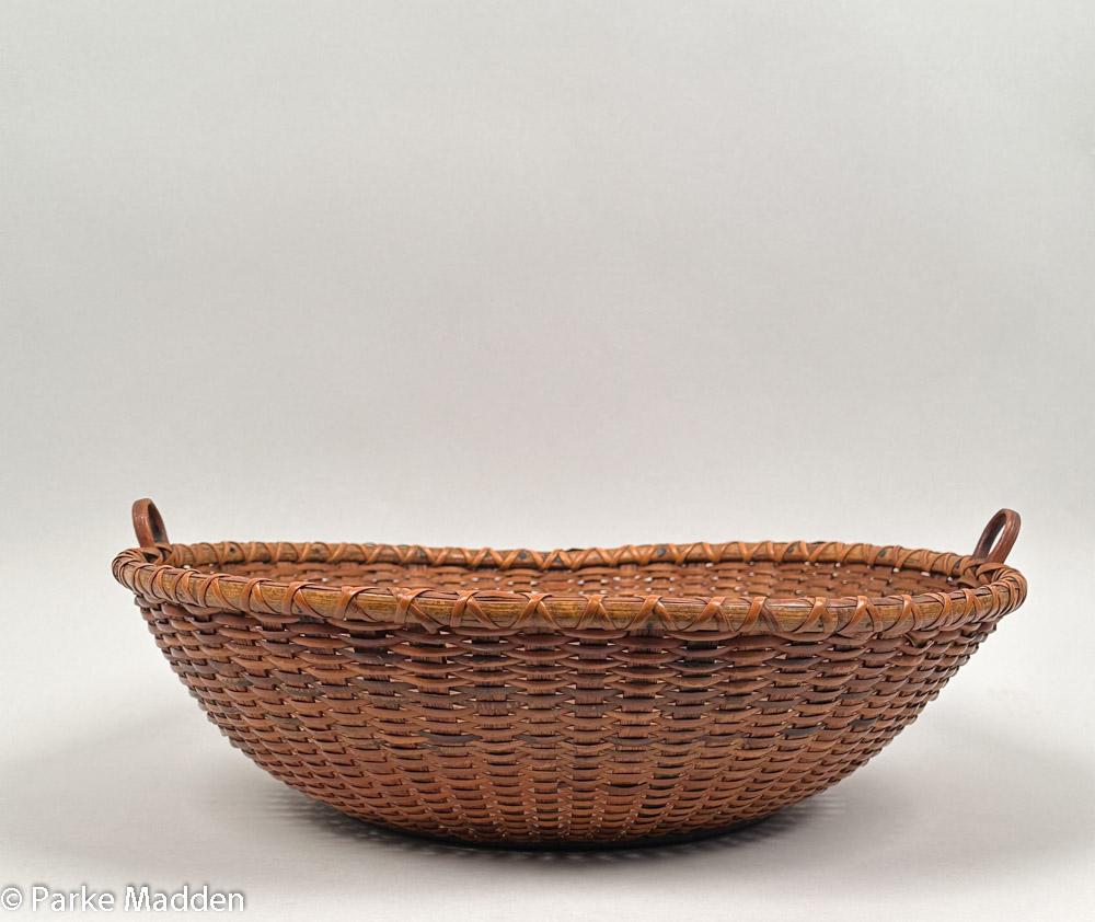 Rare forme de panier antique Nantucket Lightship Basket à large rebord. Il mesure 14,5 pouces de diamètre et seulement 4 pouces de hauteur, ce qui lui confère un design ouvert et évasé. Deux petites poignées de la taille d'un doigt ajoutent au
