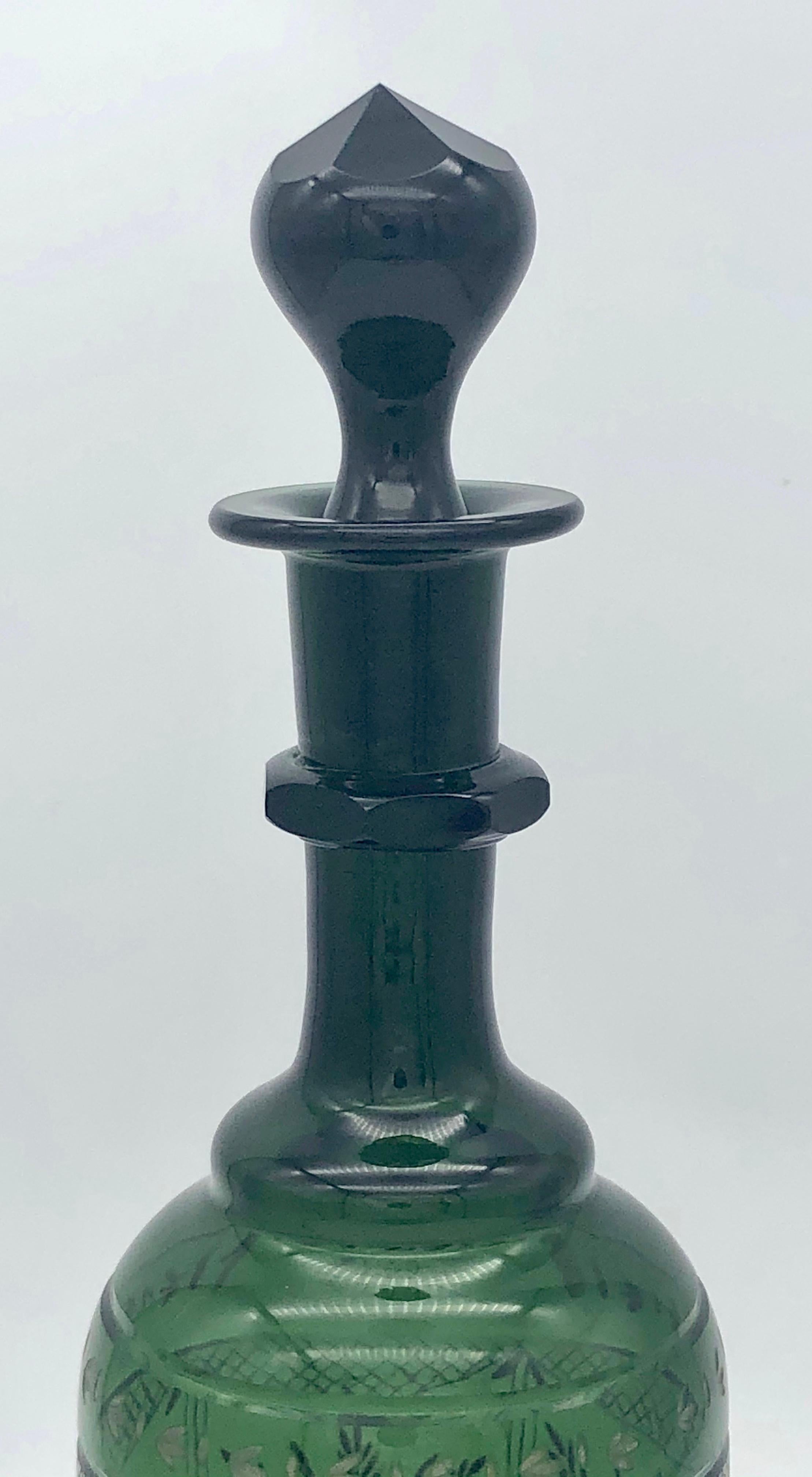This elegant tall wine decanter has been embellished with finely cut floral elements. The glass is of an intensive fir tree color and belonged to a French household.
  
