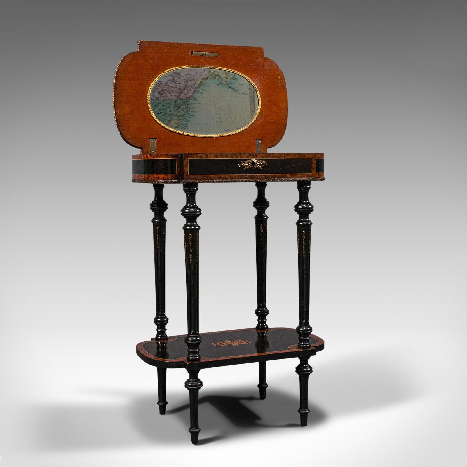 This is an antique Napoleon III side table. A French, ebonised mahogany and burr walnut etagere or sewing table, dating to the late 19th century, circa 1870.

Exquisite craftsmanship a hallmark of the Napoleon III taste
Displaying a desirable