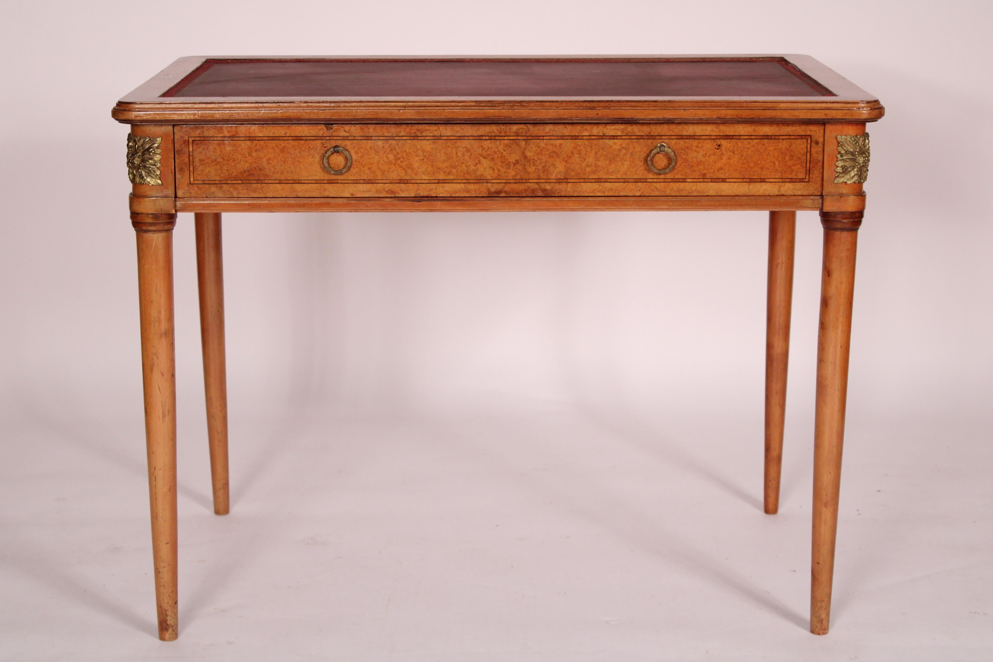 Antique Napoleon III burl ash and birch writing table, circa 1920's. With a rectangular top with rounded corners in set with a faux leather. a burl ash frieze drawer with brass laurel leaf pulls and rounded corners with chased brass mounts, resting