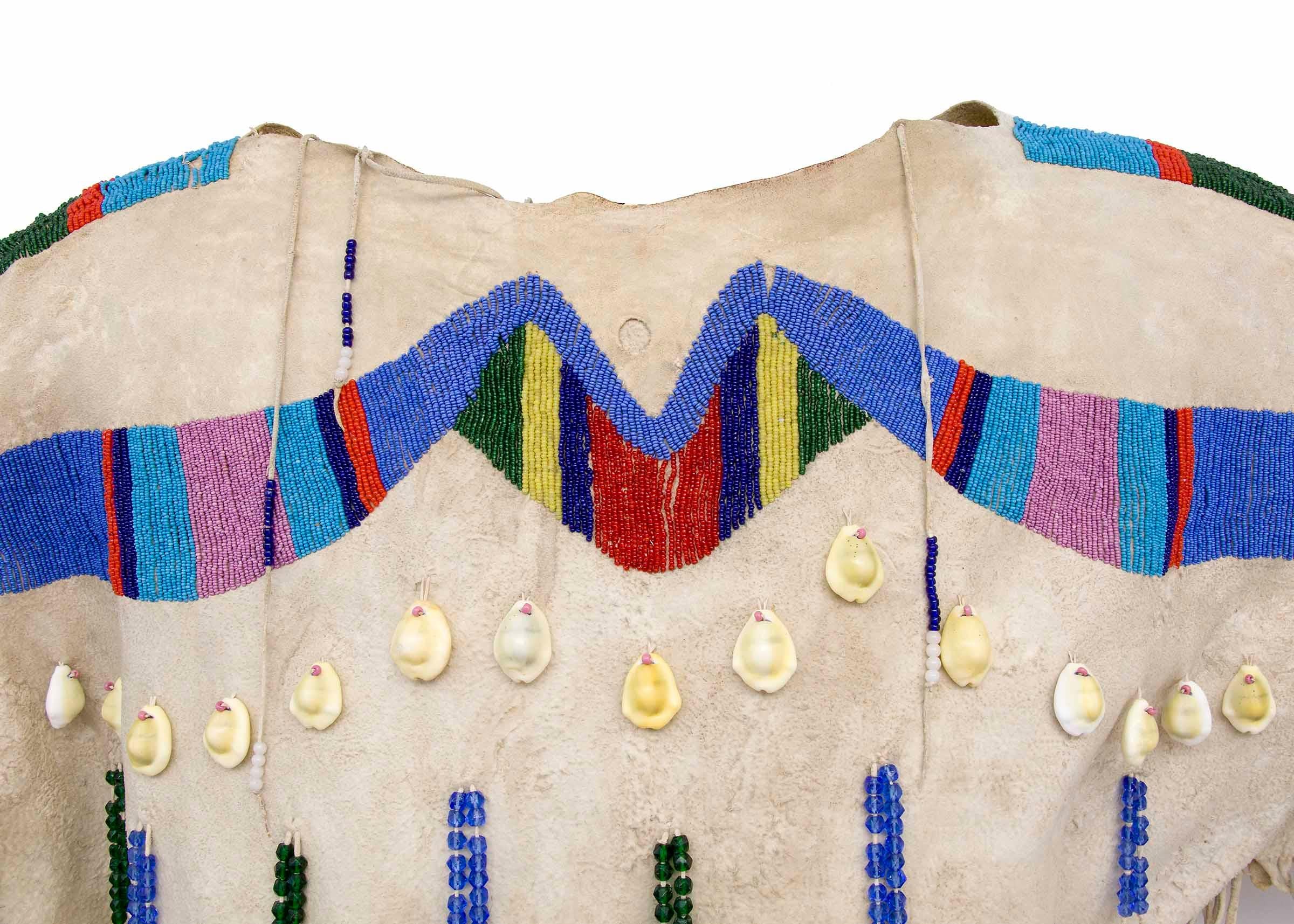 Antique beaded hide dress, Yakima, Plateau Region, Native American Indian, late 19th century, circa 1890. Traditional native-tanned hide dress is beaded across the top (yoke) in dark blue, red, green, cobalt blue, yellow, pink and Pony Trader blue