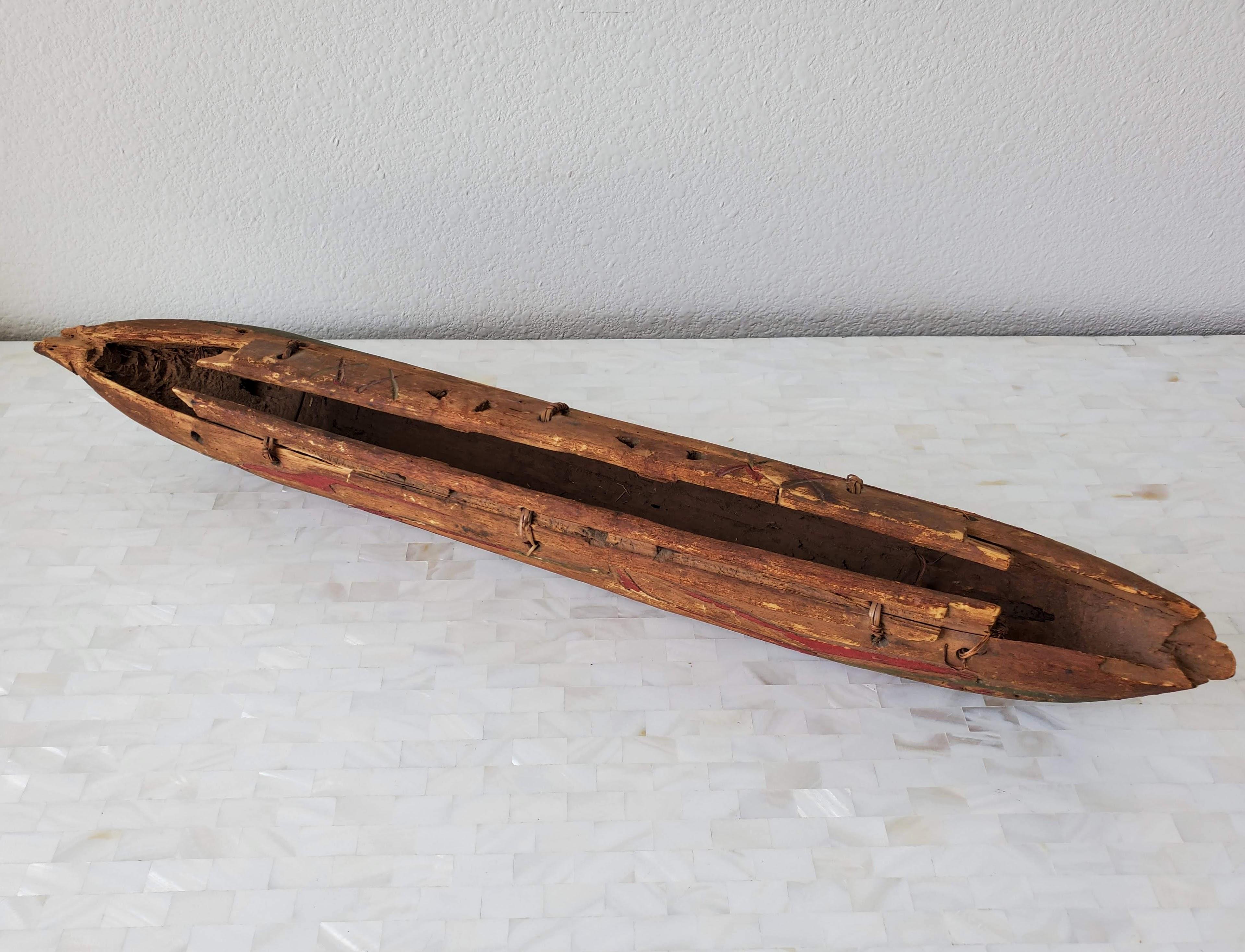 An exceptionally rare antique Native American / Indigenous Peoples hand carved and painted wooden dugout canoe model, dating to the early 20th century or earlier, likely Pacific Northwest. 

The hand-crafted miniature scale rendering having an
