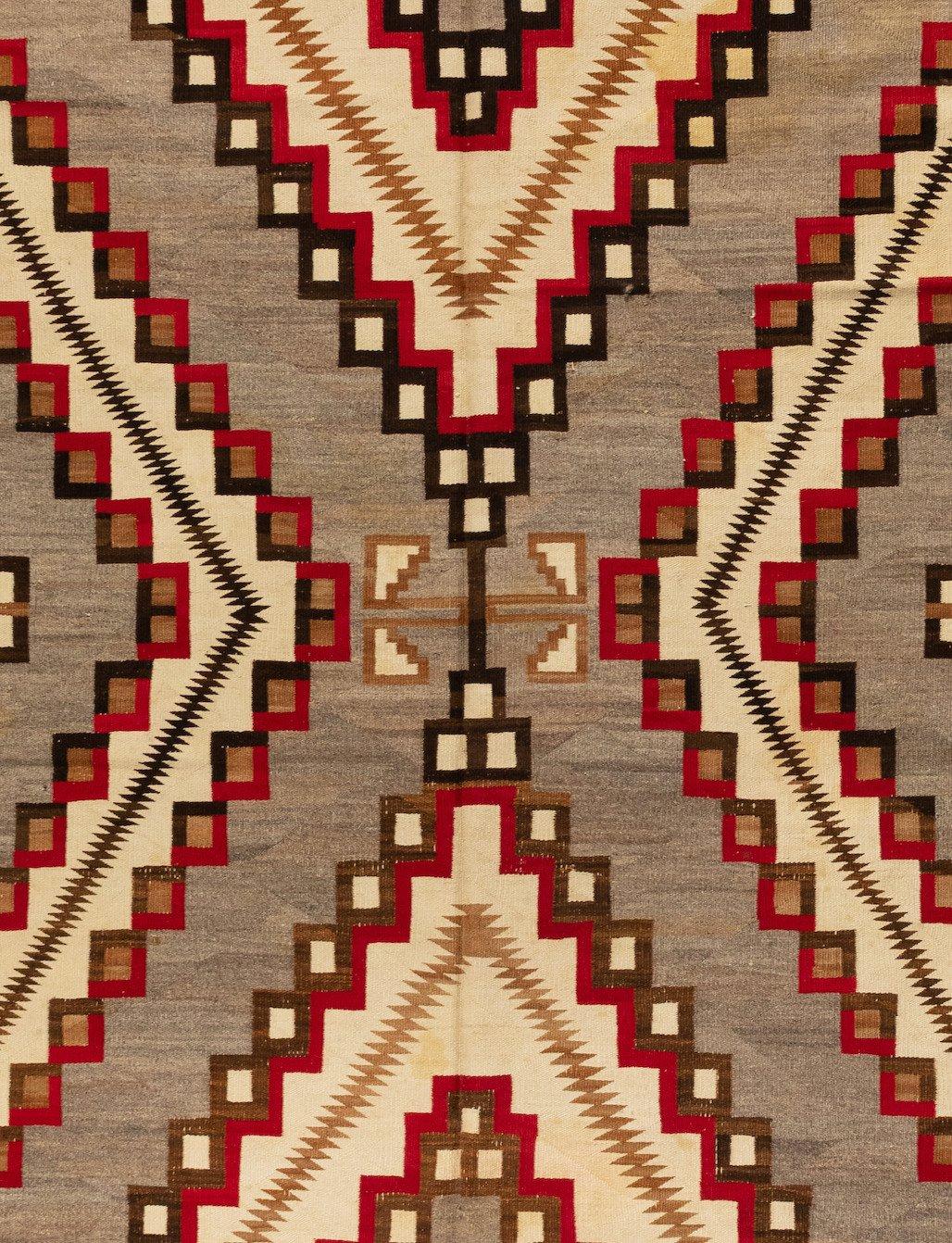 Il s'agit d'un grand, et donc rare, tapis géométrique Navajo d'Amérique du Nord, datant des années 1920-1930, en gris et ivoire, mesurant 1,2 x 3,2 mètres.

Depuis que les Navajos ont commencé à tisser, vers 1700, le tissage a constitué un