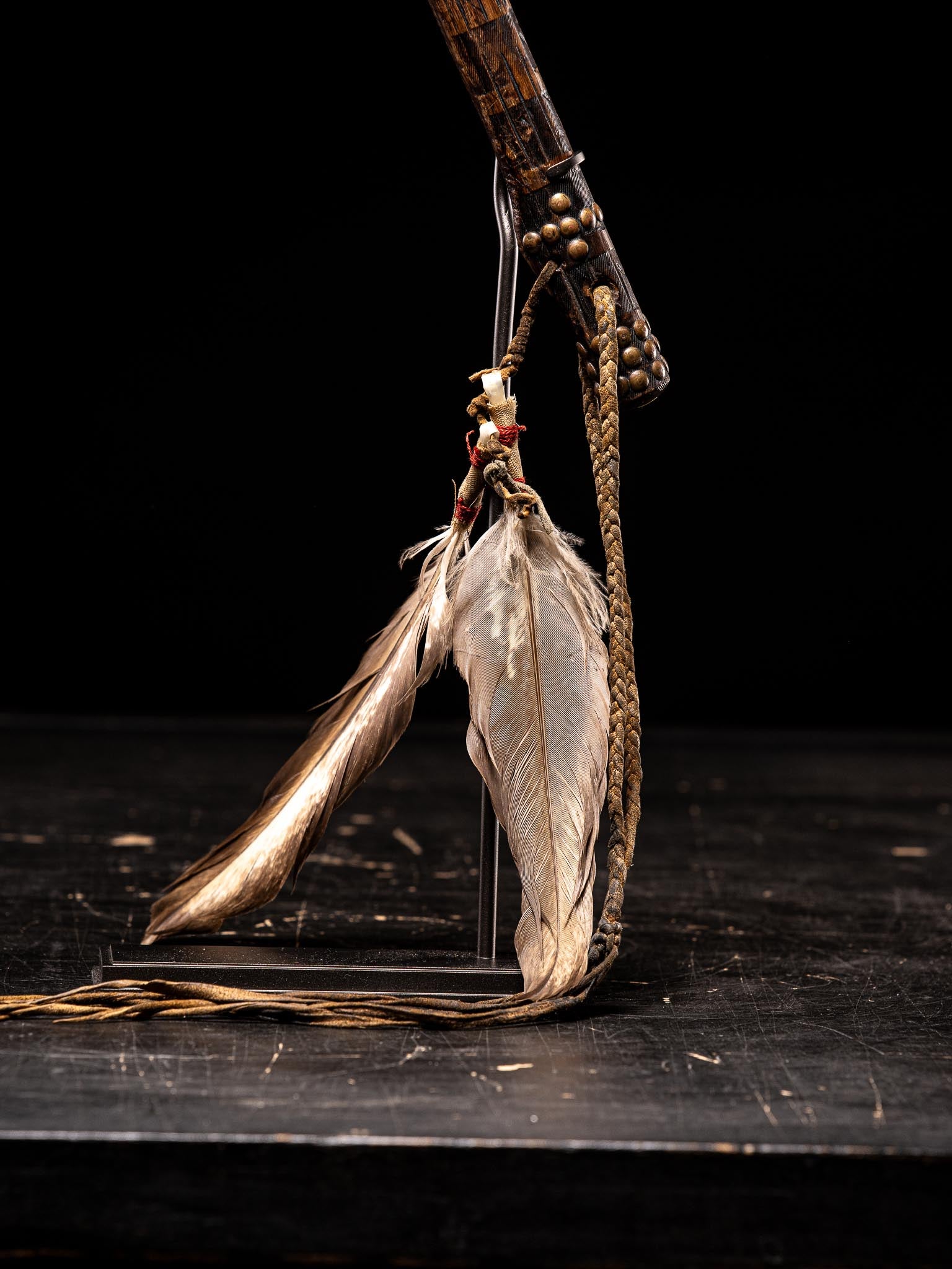 This tomahawk is nicely decorated with original copper nails and colourful  feather attributes that have been replaced in a later period.Comes with its custom made stand.