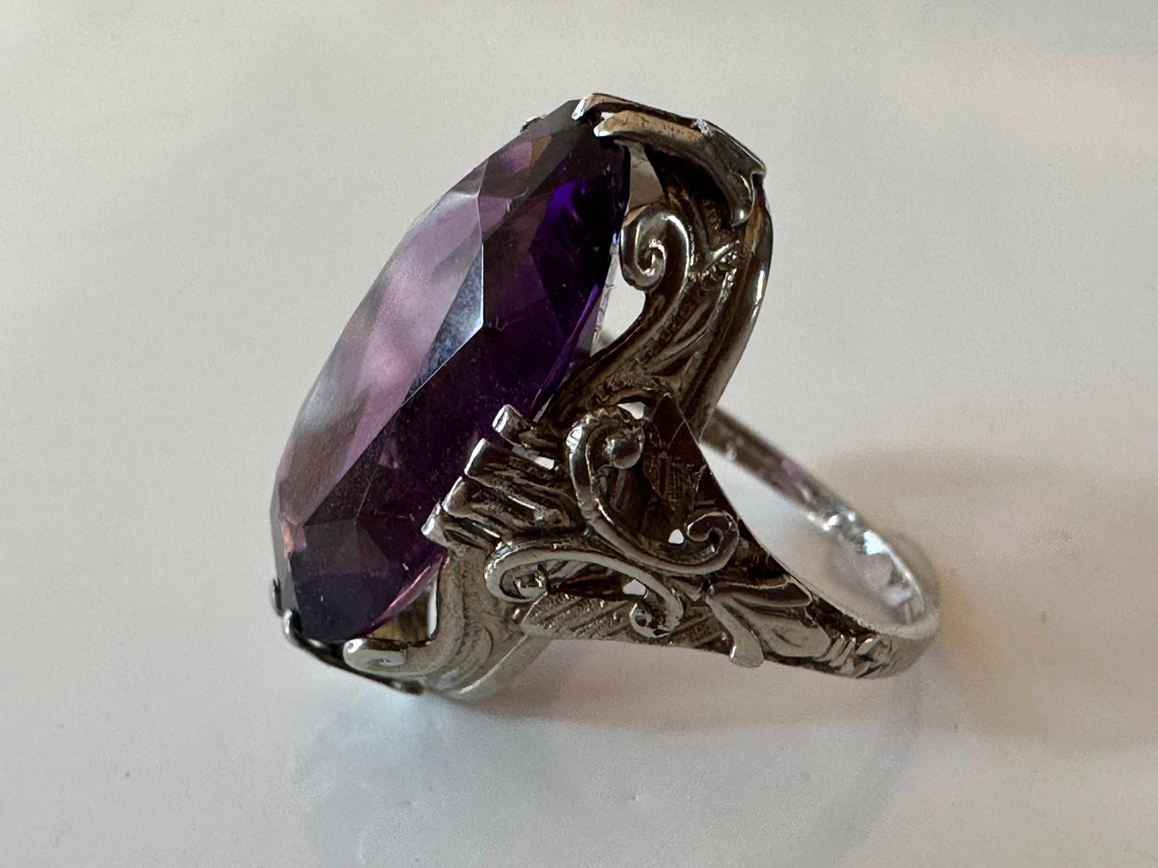 Likely crafted in the early twentieth century, this antique ring features a natural elongated oval amethyst measuring approximately 10x17.5mm presented in a 10K white gold mounting embellished with hand-engraved details. 

