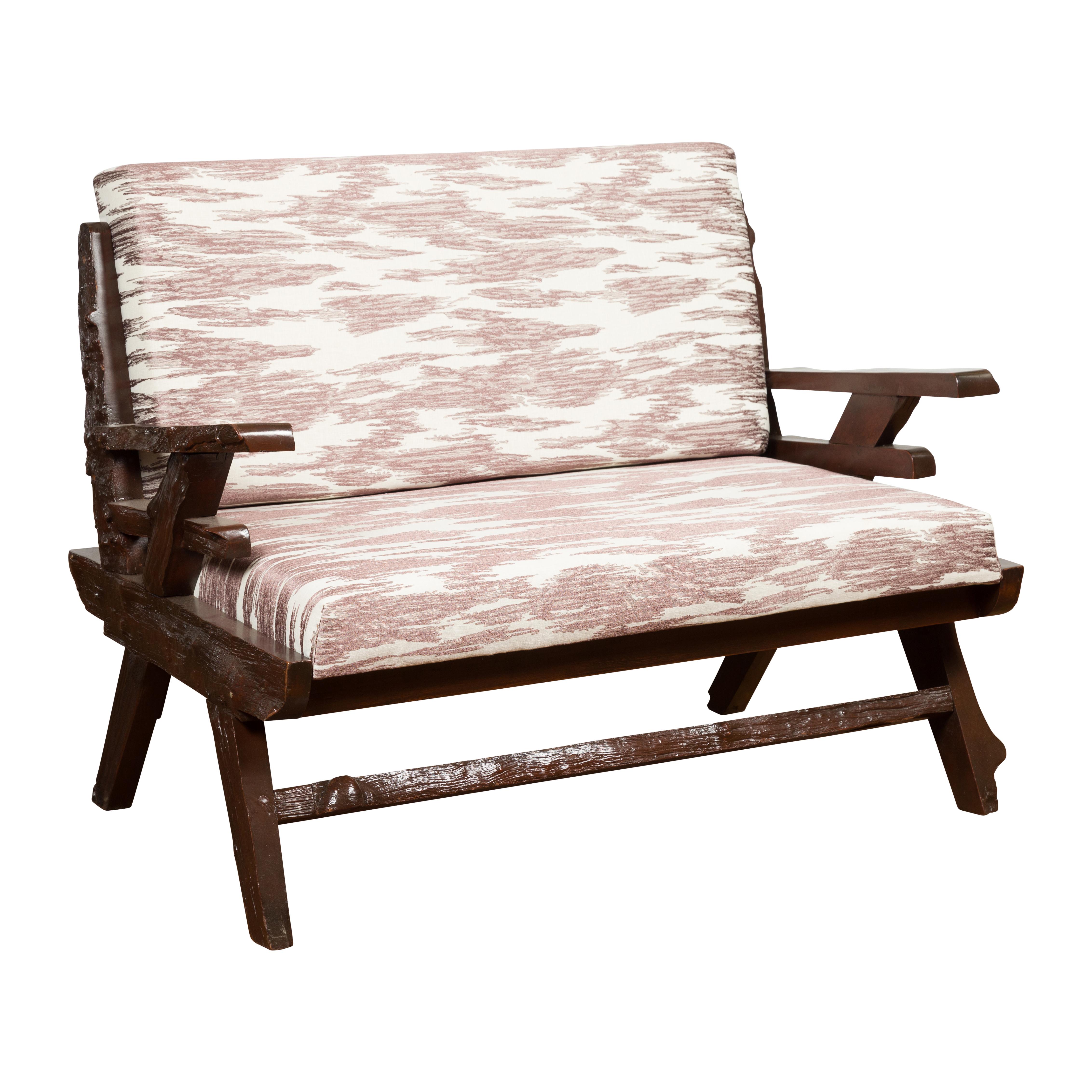 Canapé ancien en bois rustique indonésien du début du 20e siècle, avec bord naturel, tapisserie sur mesure récemment réalisée et patine foncée. Créé en Indonésie au cours des premières années du XXe siècle, ce canapé nous charme par son grand aspect