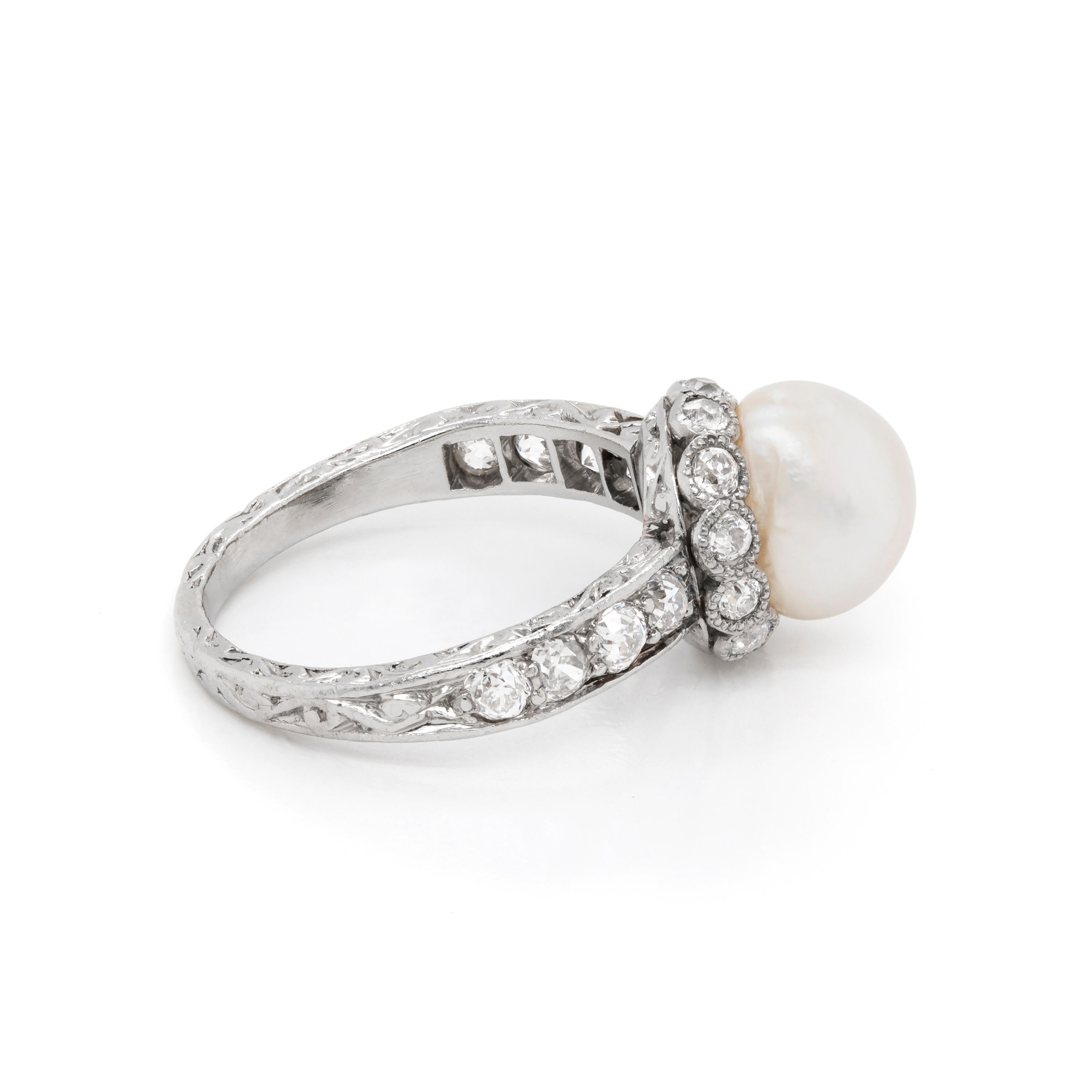 This incredible handmade antique engagement ring features a beautiful natural saltwater pearl in the center surrounded by 12 rubover set old European cut diamonds. The ring is further set with four old European cut diamonds on each shoulder bringing