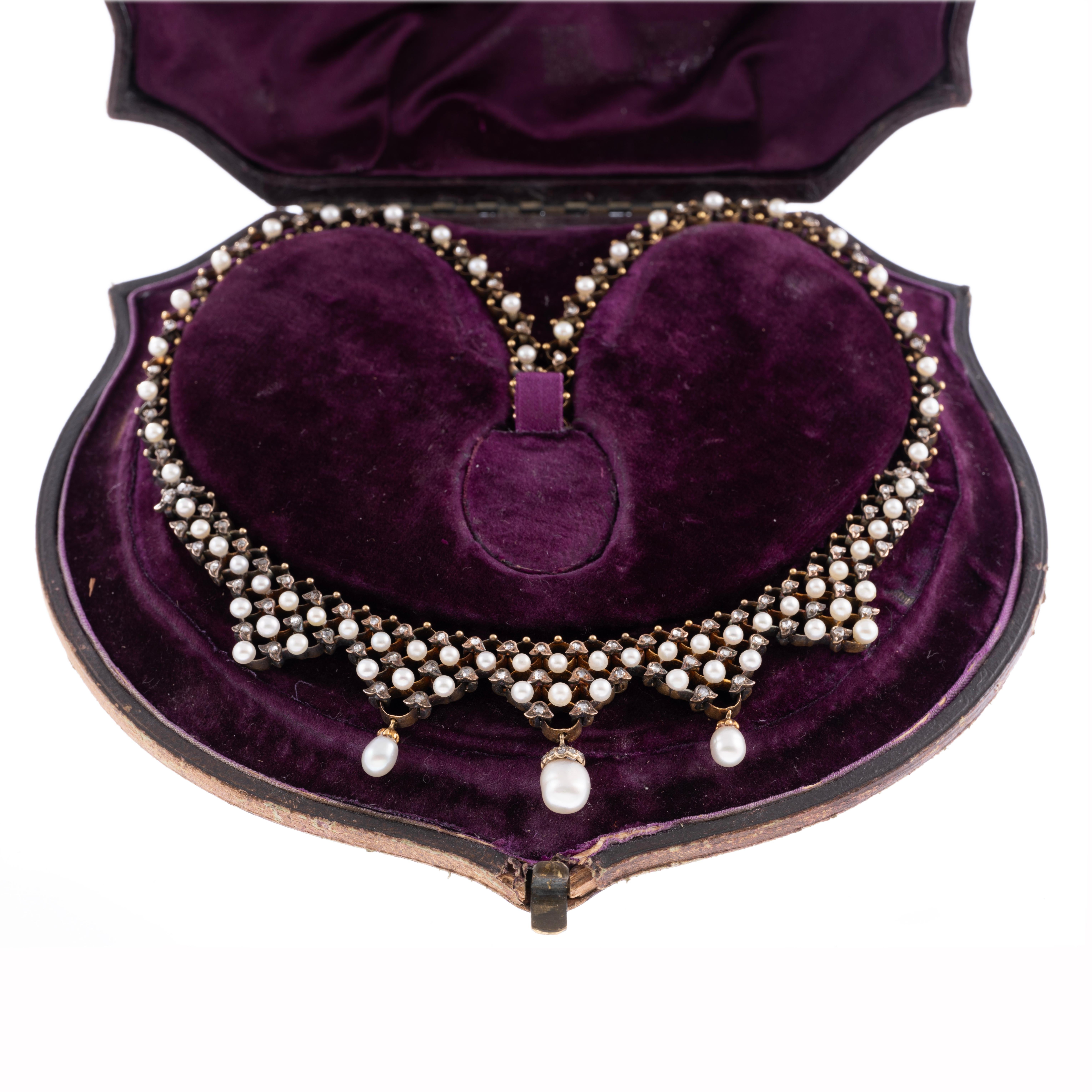 An impressive antique pearl and diamond necklace, handmade in 18k yellow gold. The pearls are likely natural pearls, far more rare and increasingly valuable. The featured pearl drop measures 7.5mm x 9mm x 6.5mm and maintains a thick nacre resulting