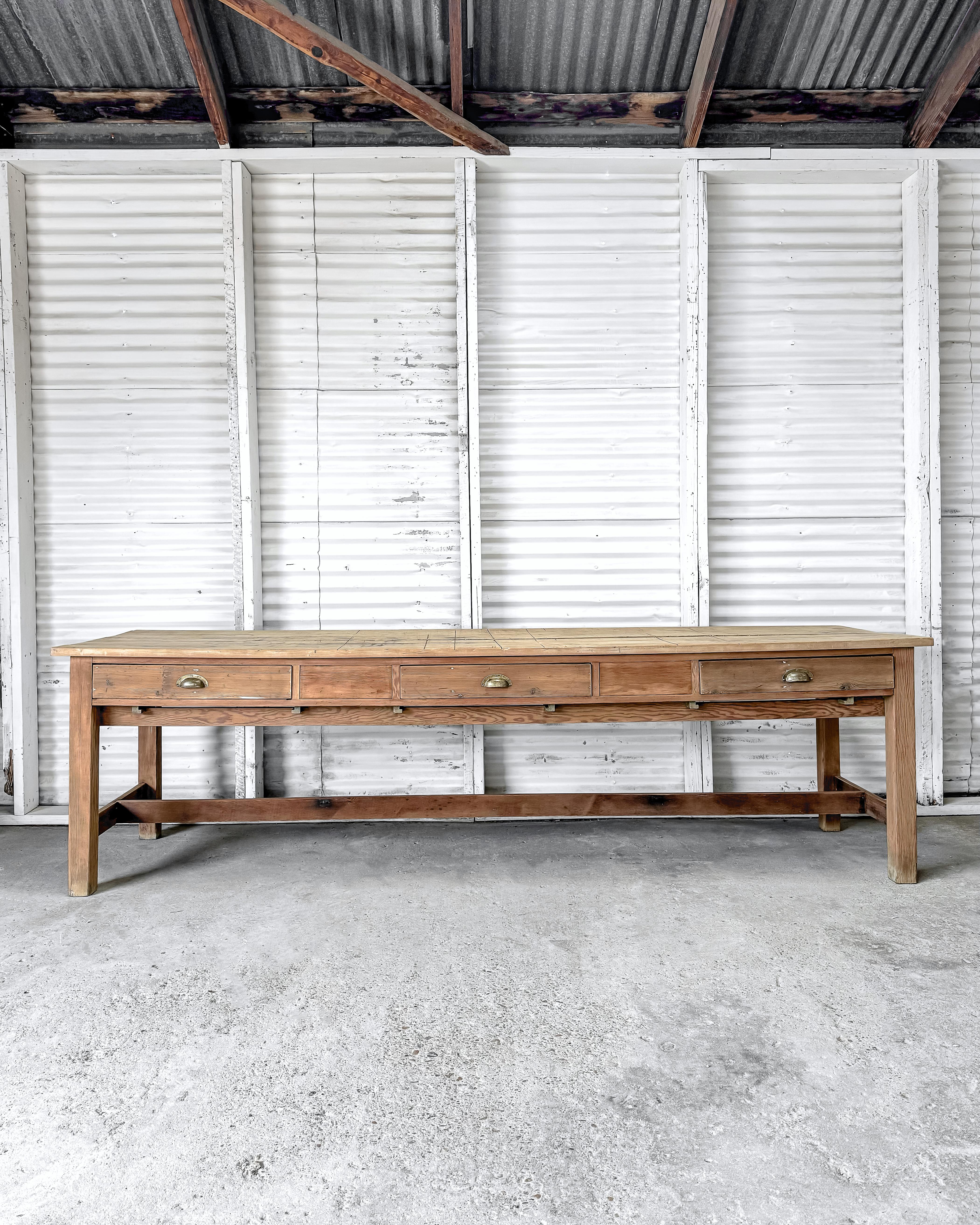 A handsome antique English pine artist's work table that would make a unique and character-filled dining table. Found in an artist's studio in England, this long and narrow table has a rich history evident in its natural pine wood top. The surface