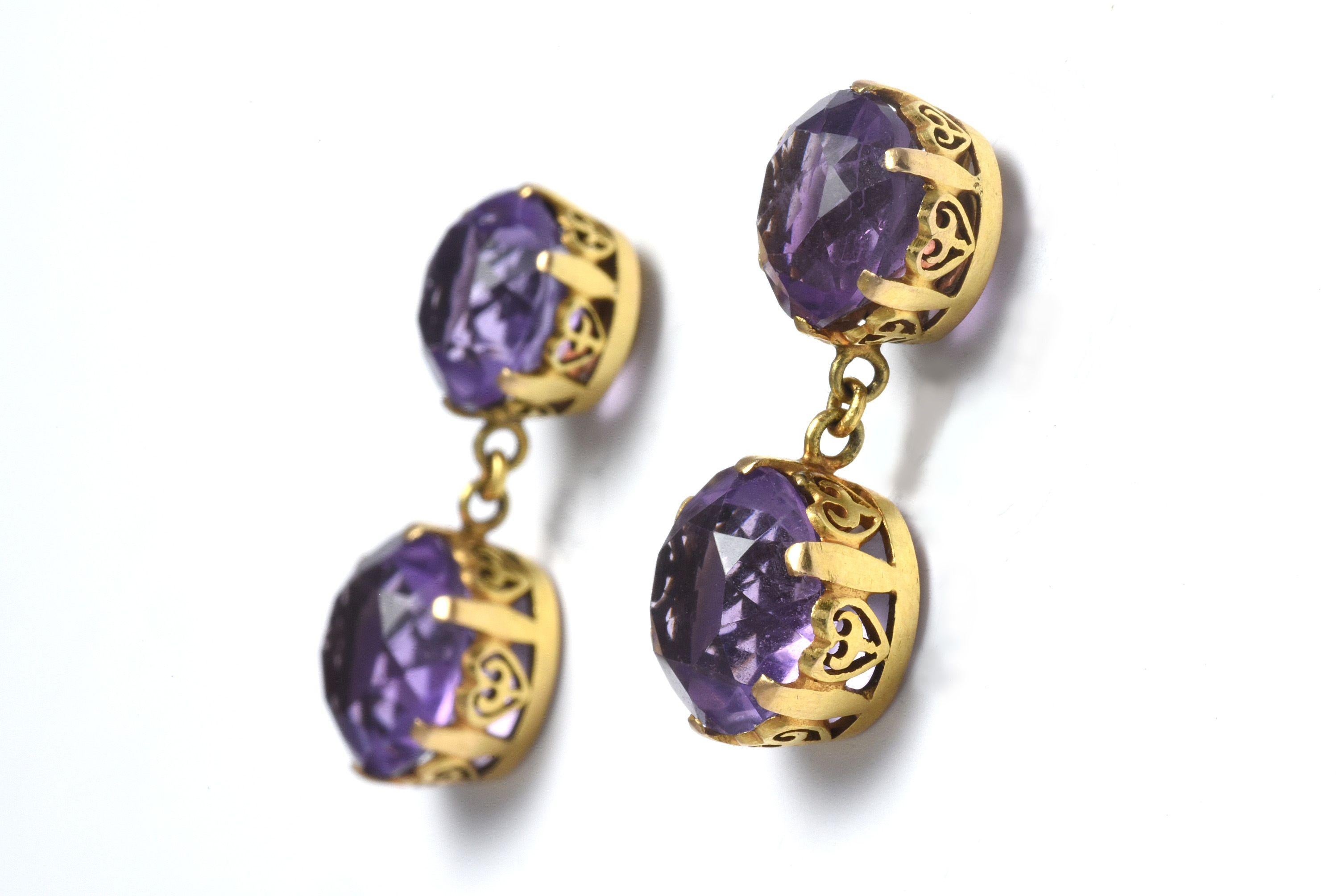 A pair of antique push back dangle earrings each center around two round natural purple amethyst gems measuring 9.5mm x 8mm crafted in 18kt yellow gold in a crown setting. Originally clip on earrings converted to push back. 
