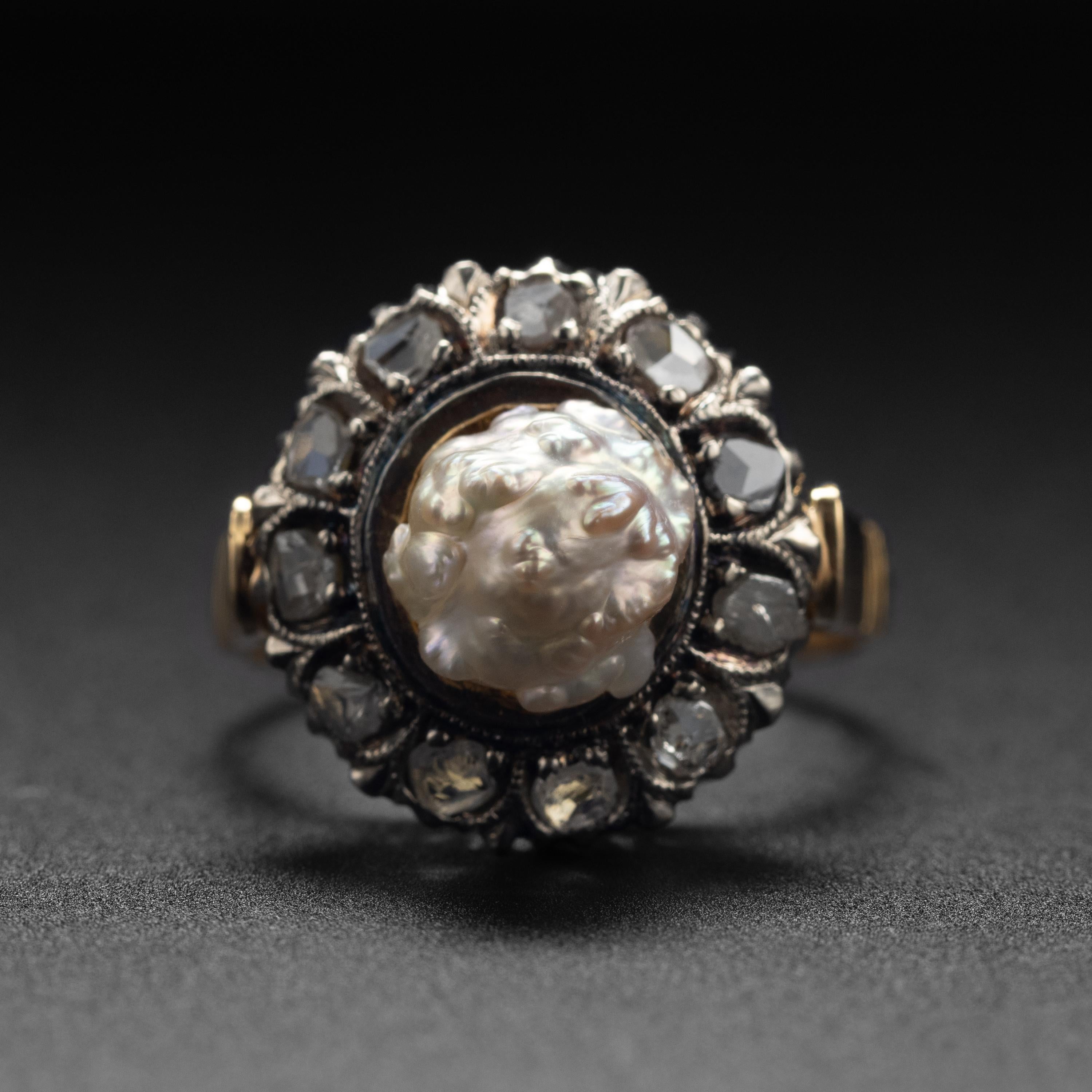 Eleven rocky old single-cut diamonds encircle a luminous, sculptural natural river pearl in this glorious ring from the 1880s. Crafted in 18K yellow gold topped with silver for the diamonds, this magnificent ring is as beautiful as it is unusual.