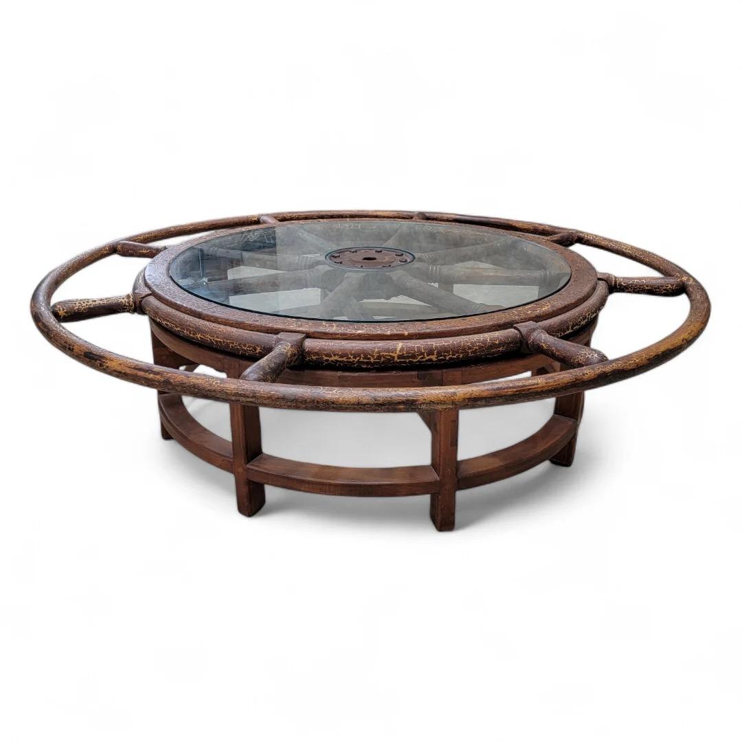 Table basse en bois et métal d'origine nautique avec roue de bateau et plateau en verre

Cette table basse unique présente une roue de navire nautique antique en bois et en métal, qui met en valeur un mélange unique d'histoire maritime et