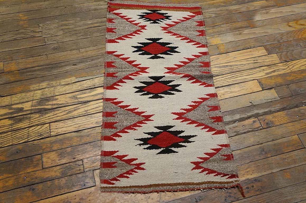 The nearly antique Navajo ruglet shows an old ivory field with four simple central ashiks in black with red lozenge centers, and with larger red and grey jagged side fillers. Erratic drawing implies that it is a child’s rug. Informal fun. Great