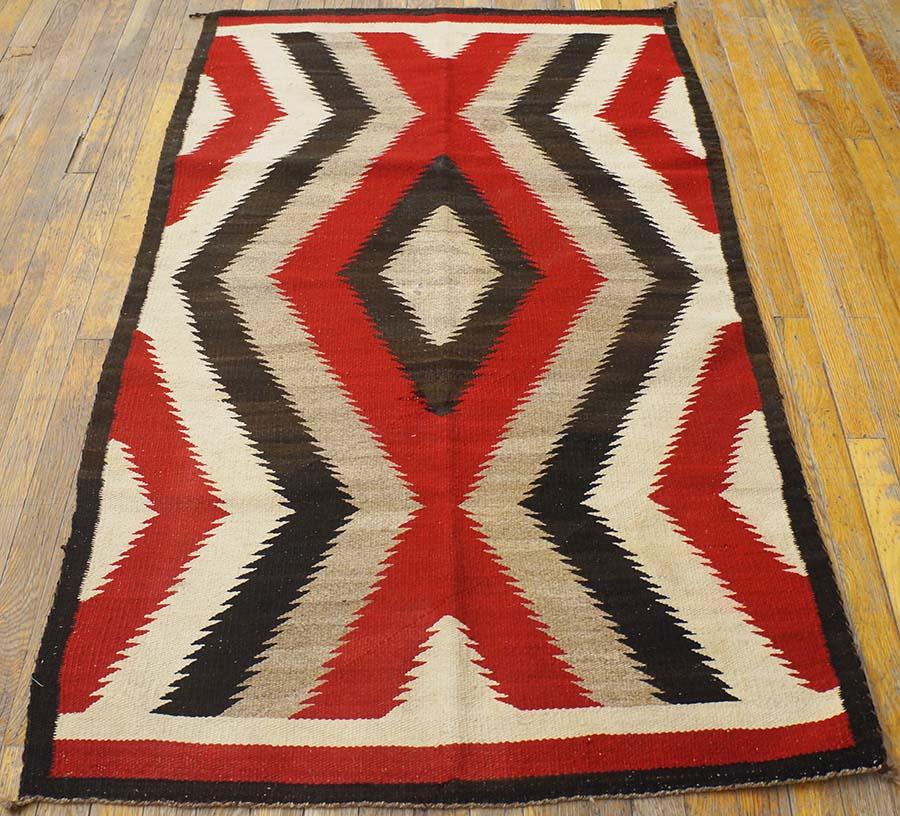 This is another of our favorite designs: a nested grey, charcoal, red and ecru wide zig-zag defines a simple lozenge center. The pattern floats vertically, above the red narrow end borders. Excellent condition. 
Measures: 3' 2