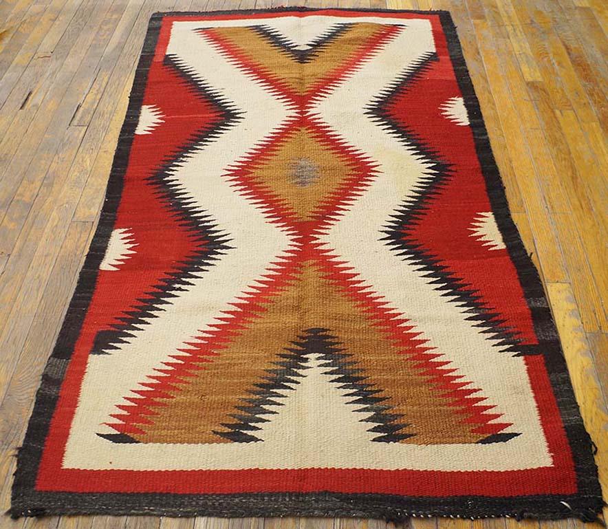 Amerikanischer Navajo-Teppich aus den 1920er Jahren (102 x 183 cm)
Ein etwas neuerer Ansatz für das Design von out 20682. Mit einer braunen, gezackten, rot umrandeten Raute, die vertikal von aufgesetzten braunen Vees flankiert wird und von