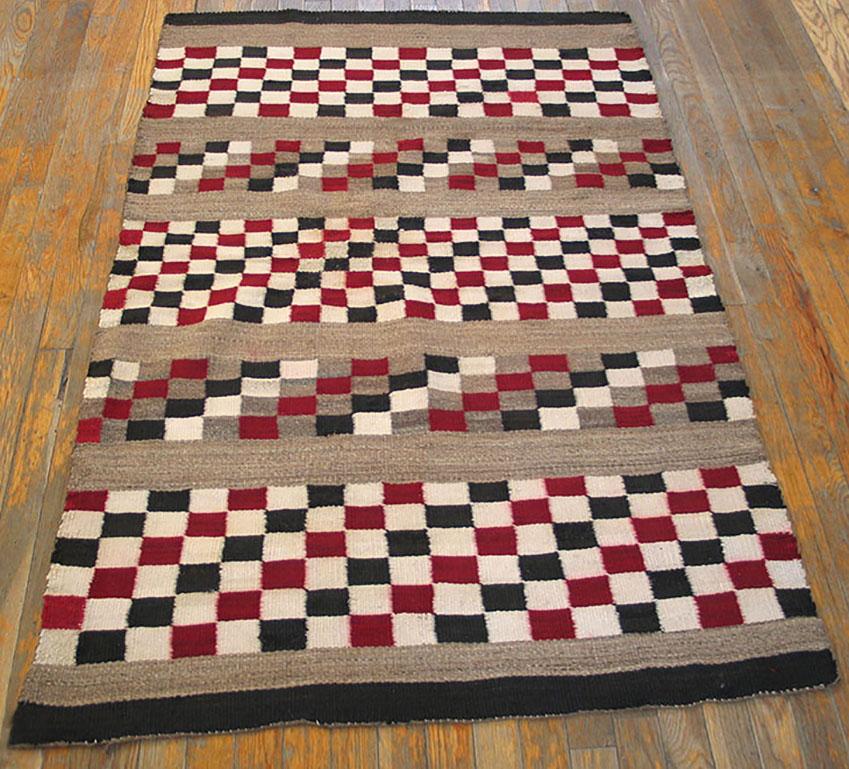 Make a few changes and you can play chess or chequers on this antique Native American scatter. Narrow light camel-grey bands divide the five main sections with small square patterns. In two the colors are oblique in grey, red, ecru and black, while