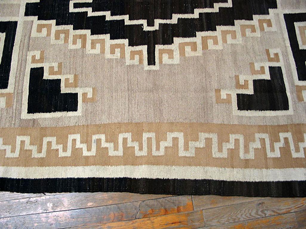 Antique Navajo rug with a black color background design and size 5'4