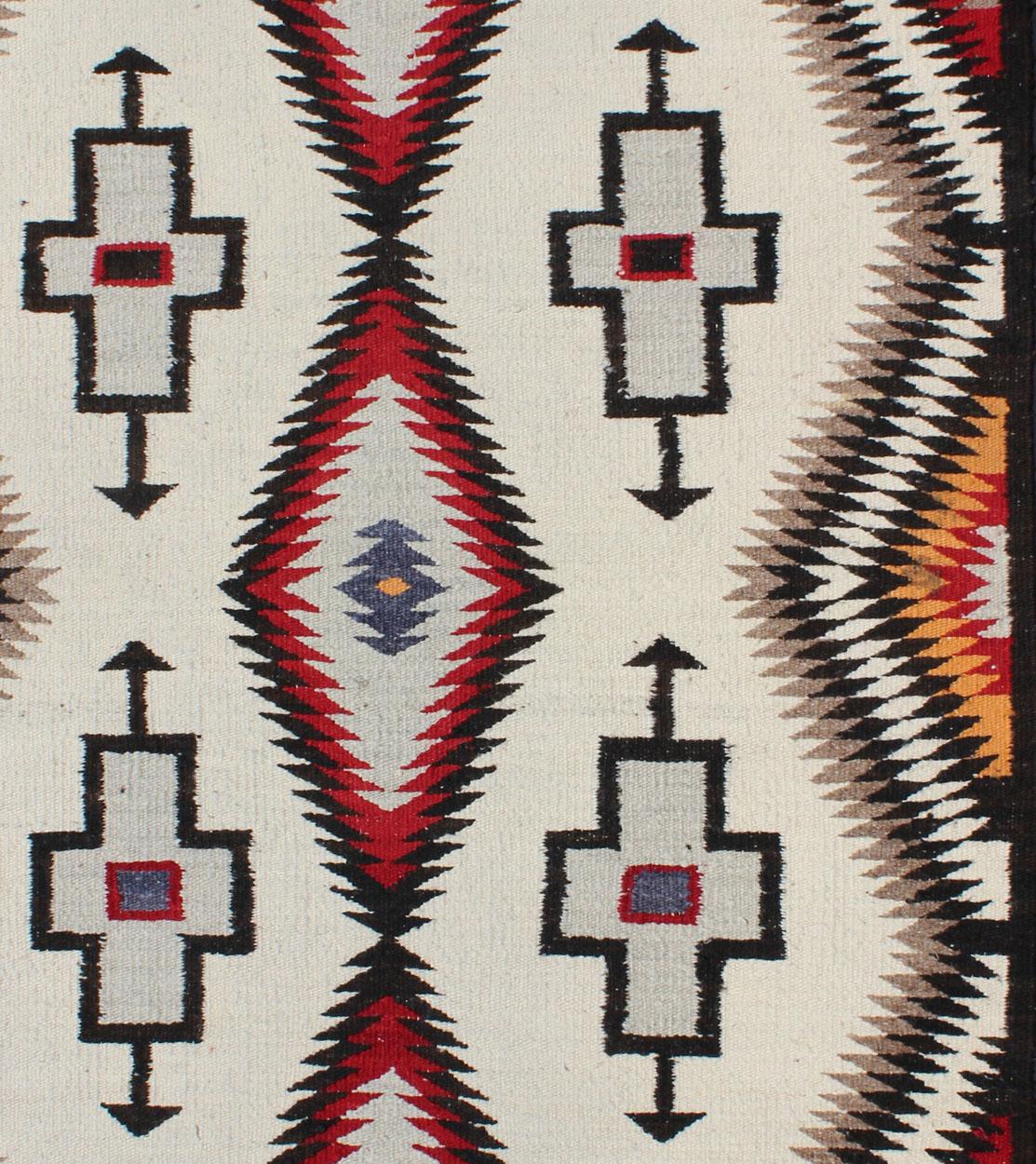 This Southwestern Navajo rug features designs and coloring most consistent with textiles that originated at the Ganado Trading Post. It's woven of native, hand-spun wool in natural colors of grey, brown, ivory, orange, black and aniline