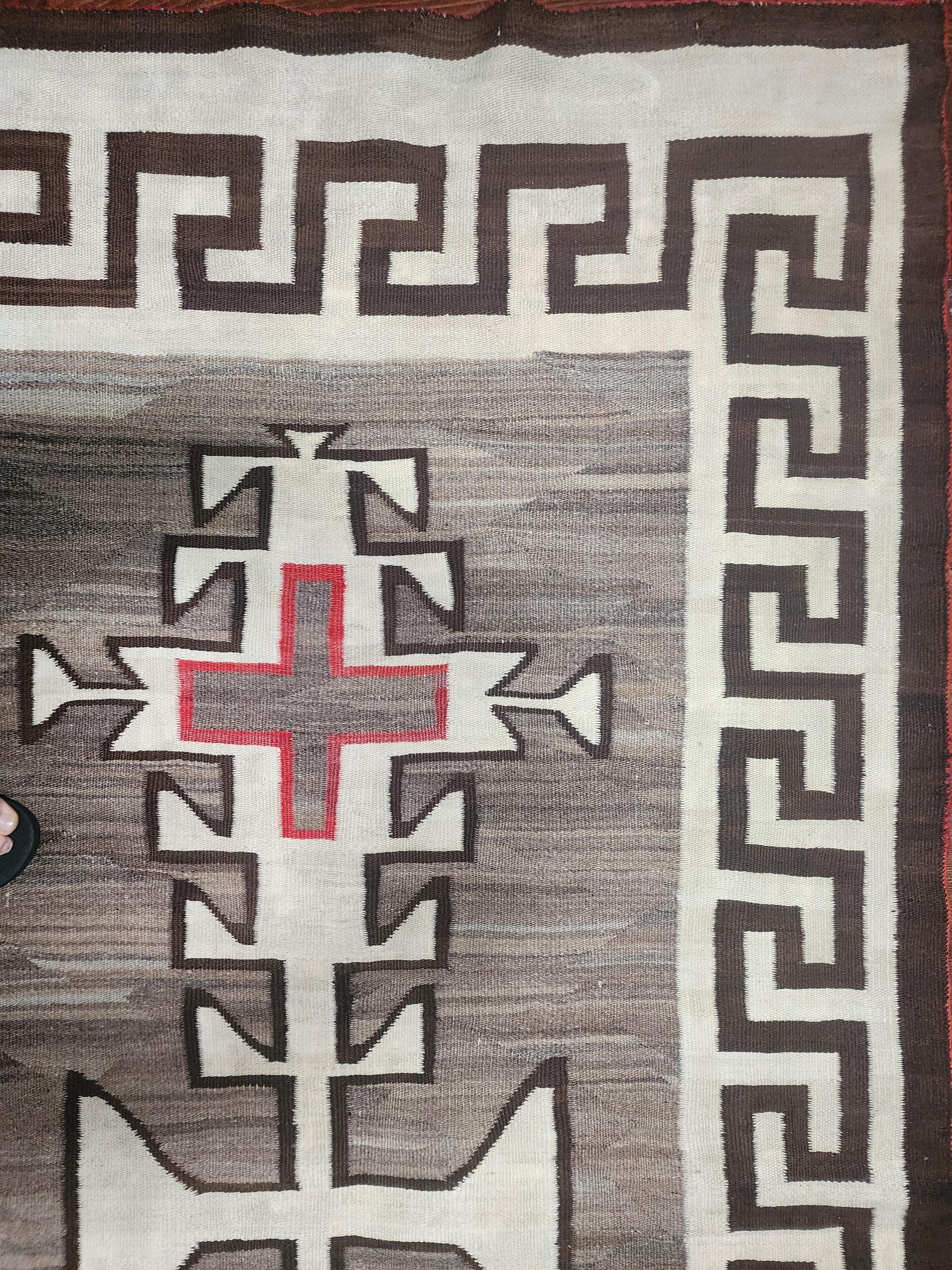 Navajo-Kristallgeflecht mit griechischem Schlüsselrand für ein sehr elegantes und modernes Design. Schöne Sprenkelung in der natürlichen braunen Wiese. Es handelt sich um eine übliche Weberei mit Emblemen der Spinnenfrau. Diese Weberei ist in gutem