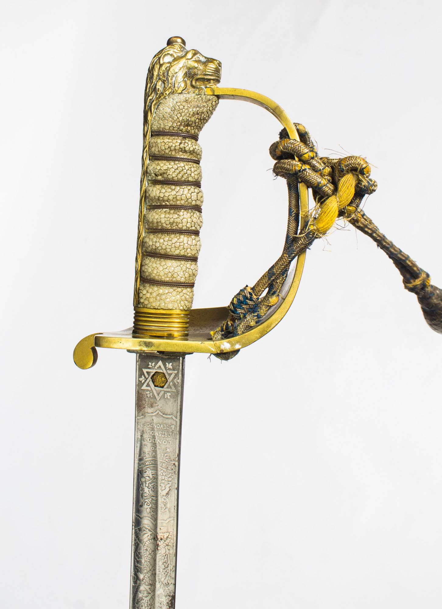A superb Victorian officers sword in leather mounted scabbard by Henry Wilkinson, Pall Mall, London, retailed by Gieves Ltd of London, dated 1897.

The sword features a brass lions head hilt and has a brass guard with a crown over an anchor and a