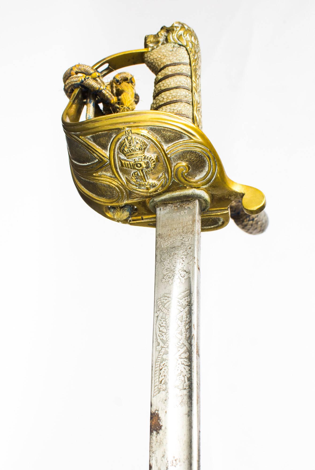 A superb Naval officers sword by Henry Wilkinson, Pall Mall, London, retailed by Gieves Ltd of London, circa 1897 in date.

The sword features a brass lions head hilt, and a brass guard with shagreen hilt, the guard with a crown over an
