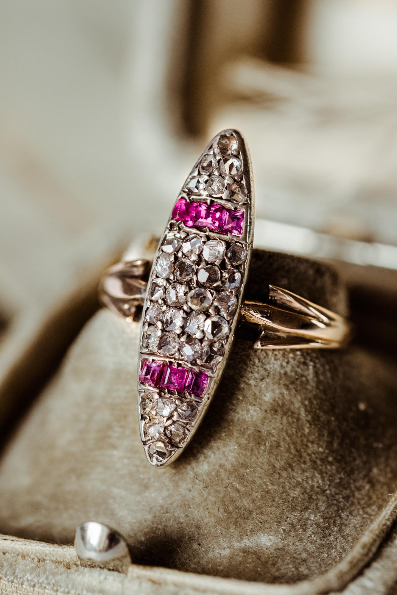 A beautiful navette Art Deco diamond ring! Set with natural diamonds and calibrated rubies this substantial gold ring was handcrafted almost 100 years ago and has stories untold. It is adorned with 20 square rubies and 30 sparkling diamonds with a