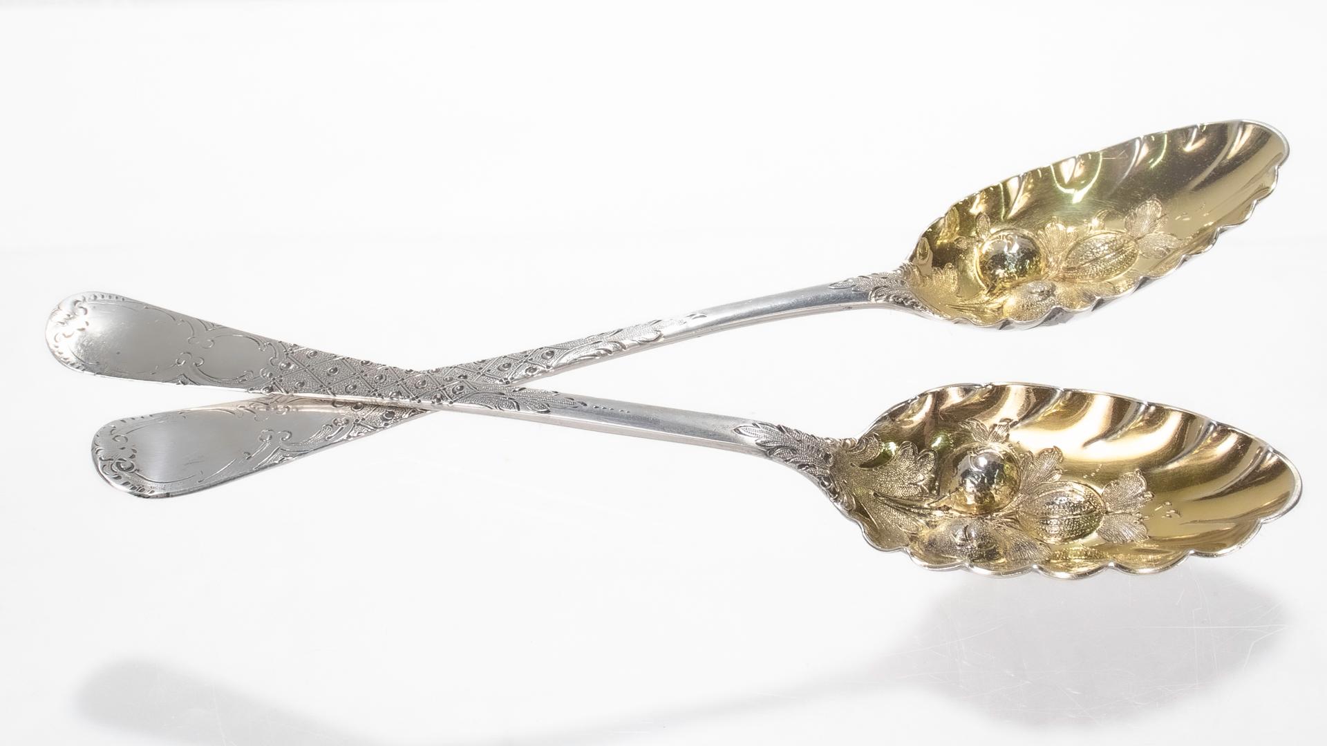 A fine near pair of antique Georgian berry spoons.

In sterling silver.

One marked for William Fearn of London and 1776; the other marked for Thomas & William Chawmer of London in the 1760s. 

With repoussé decoration to the bowls, gilding, and