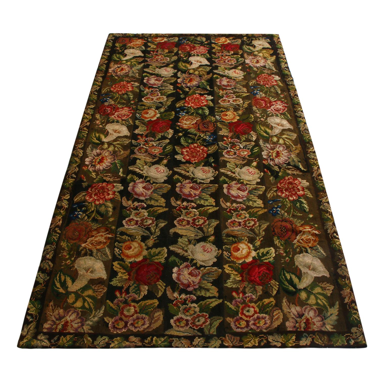 Hand stitched in high-quality wool originating from England in 1910, this antique needlepoint floral rug enjoys exceptionally fine detail and a complementary array of crimson red, cream white, lavender and vibrant orange colorways against the column