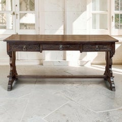Bureau antique néo-gothique à trois tiroirs, en chêne sculpté, sur tréteaux