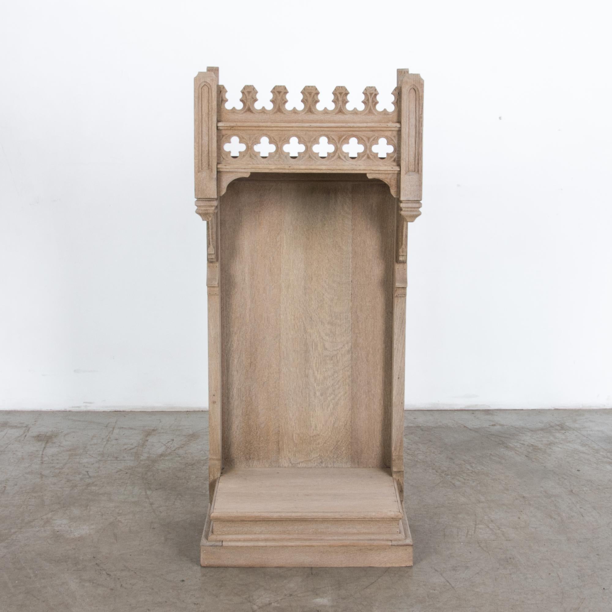A Gothic style oak stand from circa 1900, France. Originally used for supporting a small statue, this intriguing piece has a multifaceted shape, with a lower niche topped with an enclosed shelf. Textured wood grain is complimented by carved