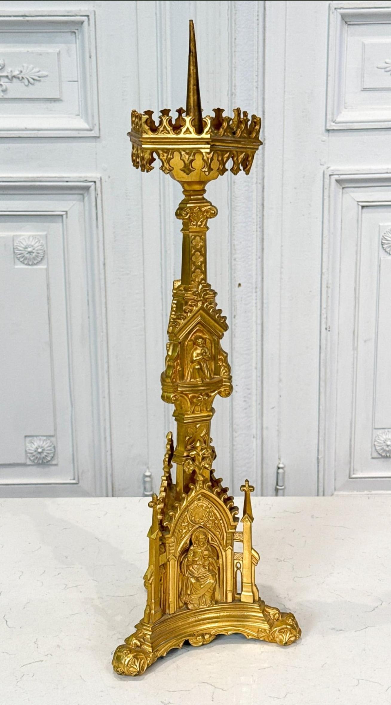 A stunning Late Victorian Neo-Gothic gilt bronze altar stick pricket candlestick. Late 19th to early 20th century, the Continental European antique features an exceptionally executed sculptural form, intricately detailed throughout, with religious