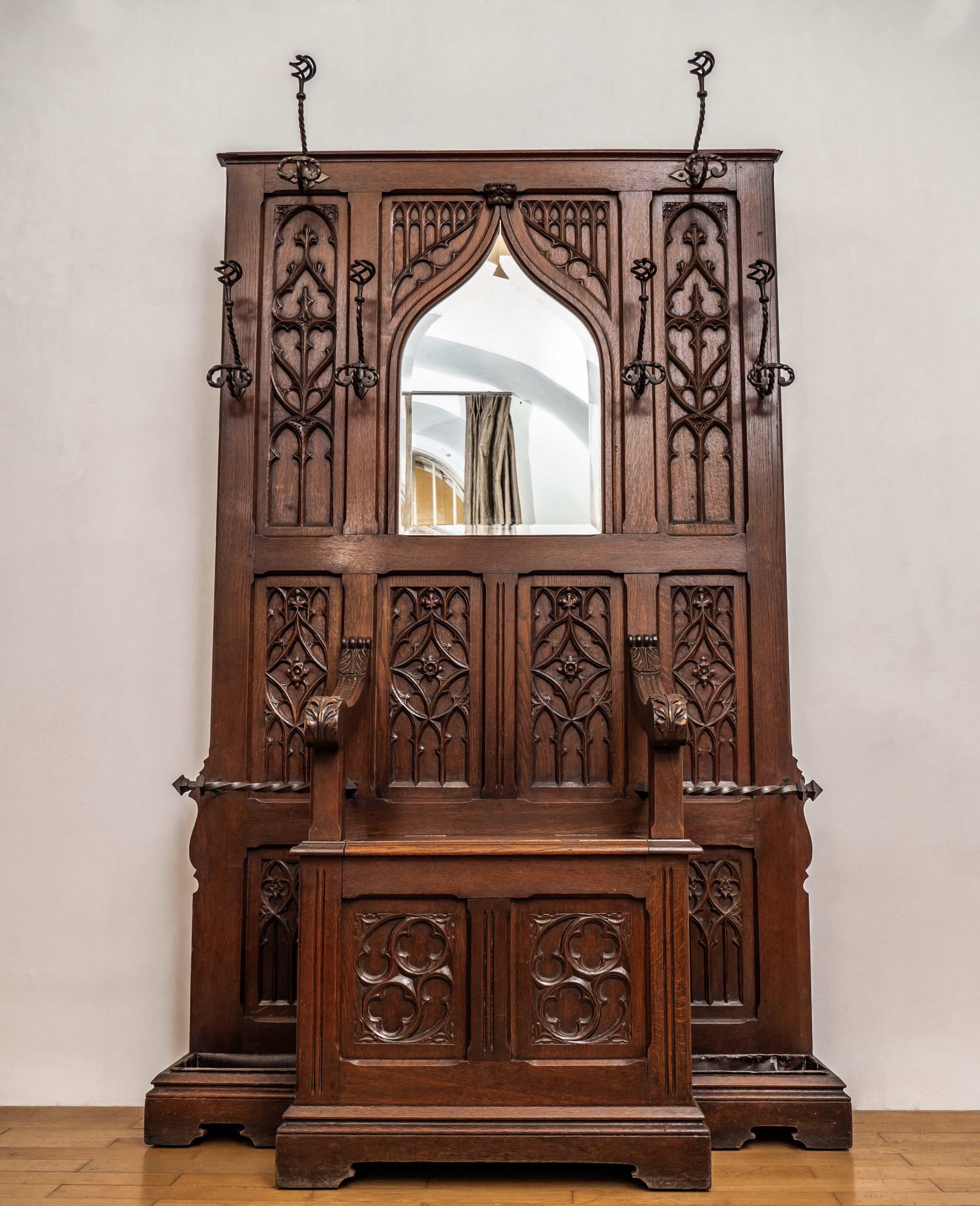 Hand-carved wall from solid oak in Gothic style. Excellent quality of artistic craftsmanship, where the entire wall is made of selected oak and precisely carved into fine details. The wall has a central bench with storage space and armrests, along