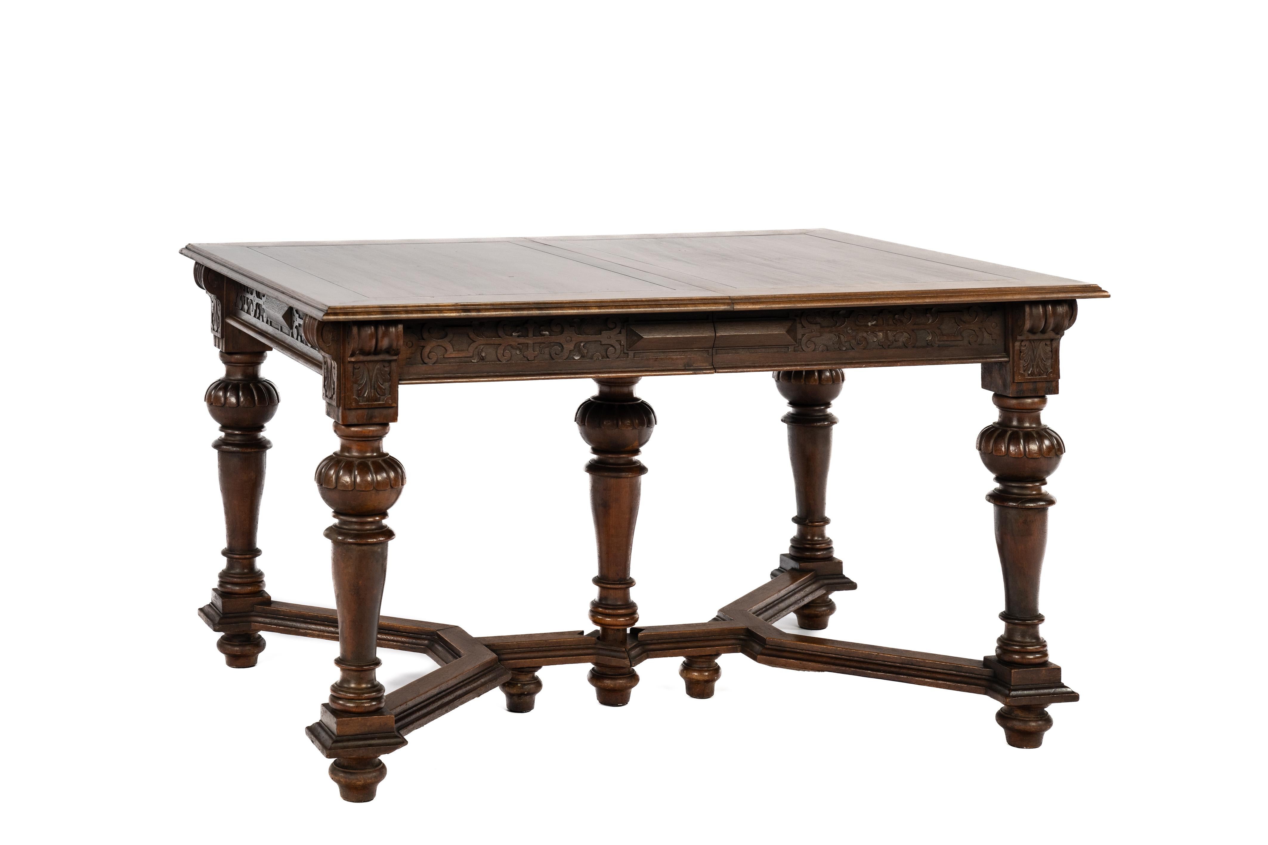 Offered here is an antique draw-leaf table made in France around 1870. The table is entirely crafted in cherry wood and is richly adorned with classical ornaments originating from the Renaissance period. The stylized acanthus motifs, the geometric