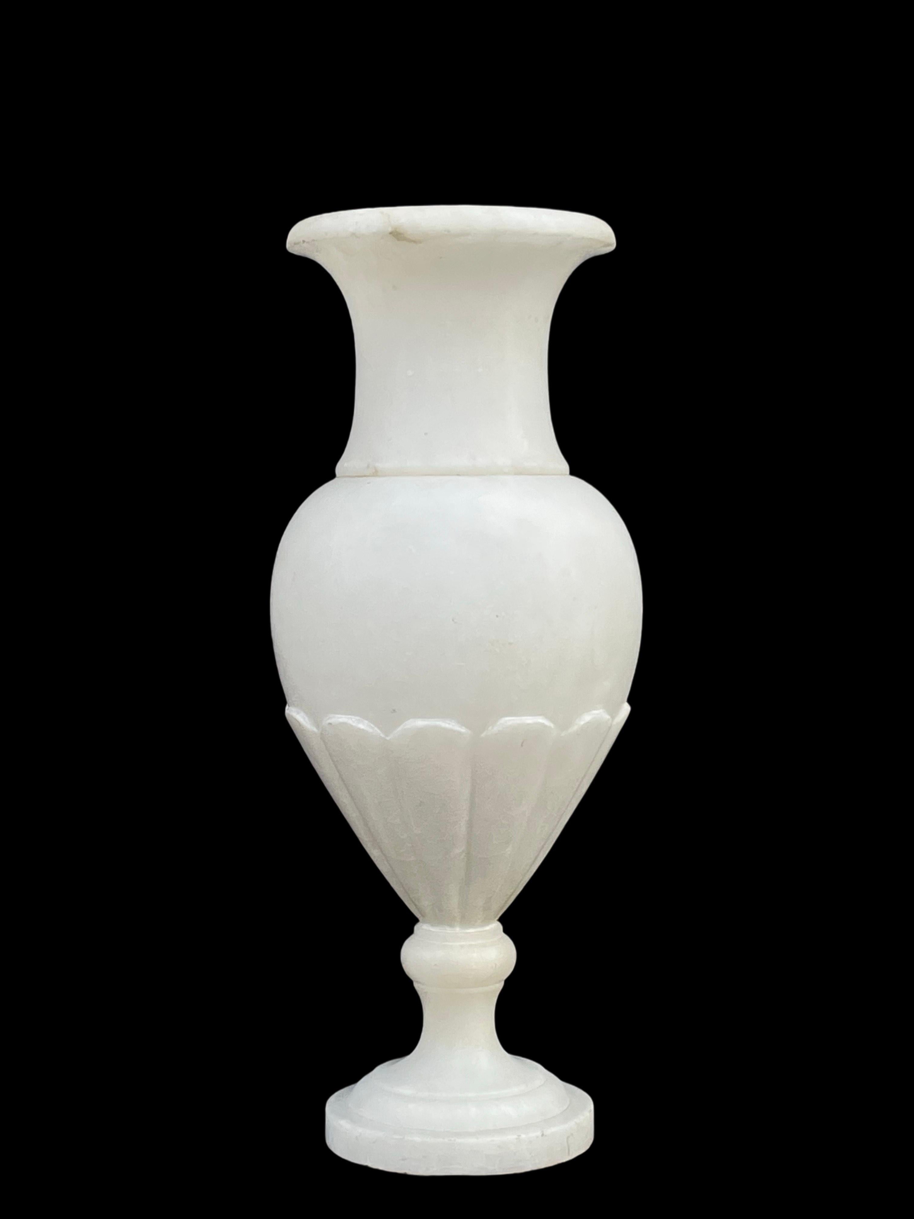 Cette exquise lampe de table néoclassique en albâtre, datant des années 1920 à 1930, est un exemple étonnant d'élégance intemporelle.

Son corps gracieux en forme d'urne présente des détails finement sculptés sur la moitié inférieure, ce qui ajoute