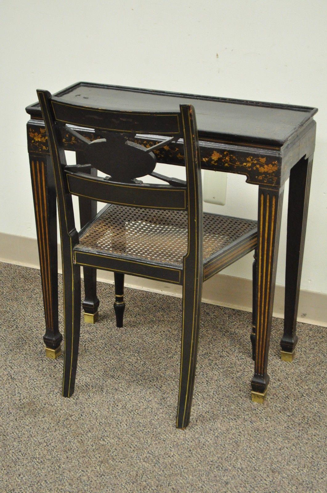 Antique neoclassical or directoire style telephone stand and accent chair. Item features caned seat side chair, black lacquered finish with gold accents, brass capped feet on table, floral decorated table top and skirt, carved arrow back with