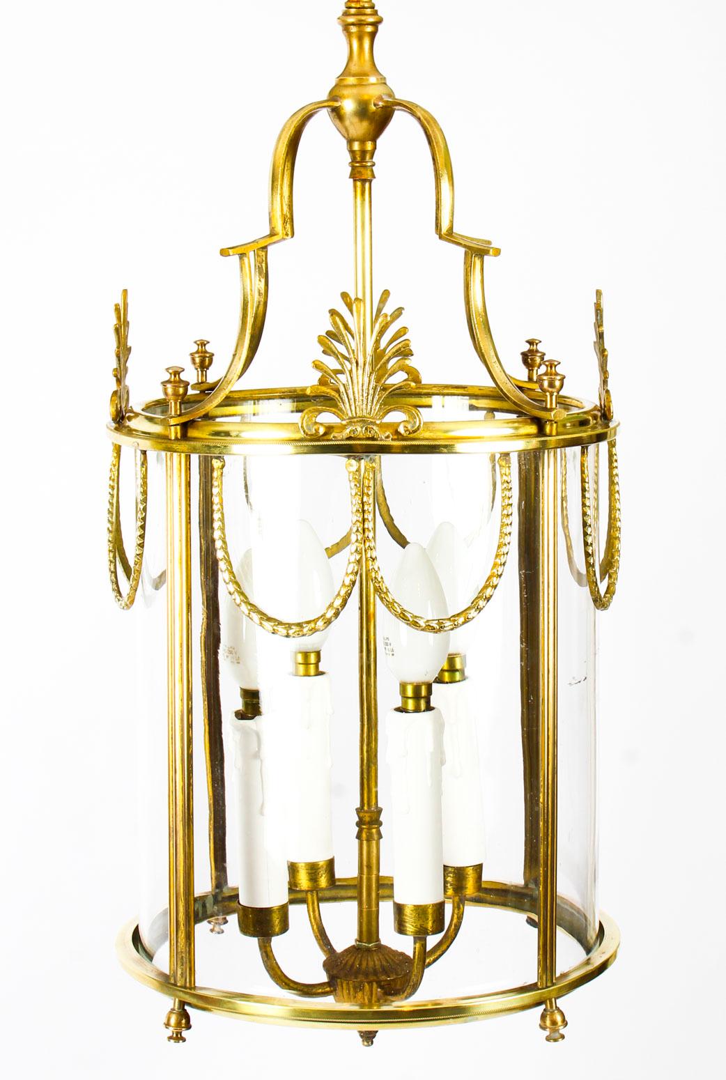 This is an elegant antique neoclassical hanging lantern made of solid brass, circa 1890 in date.

This sophisticated lantern is of circular shape and features a four light pendant which drops off a scrolled canopy.

The frame panels have highly