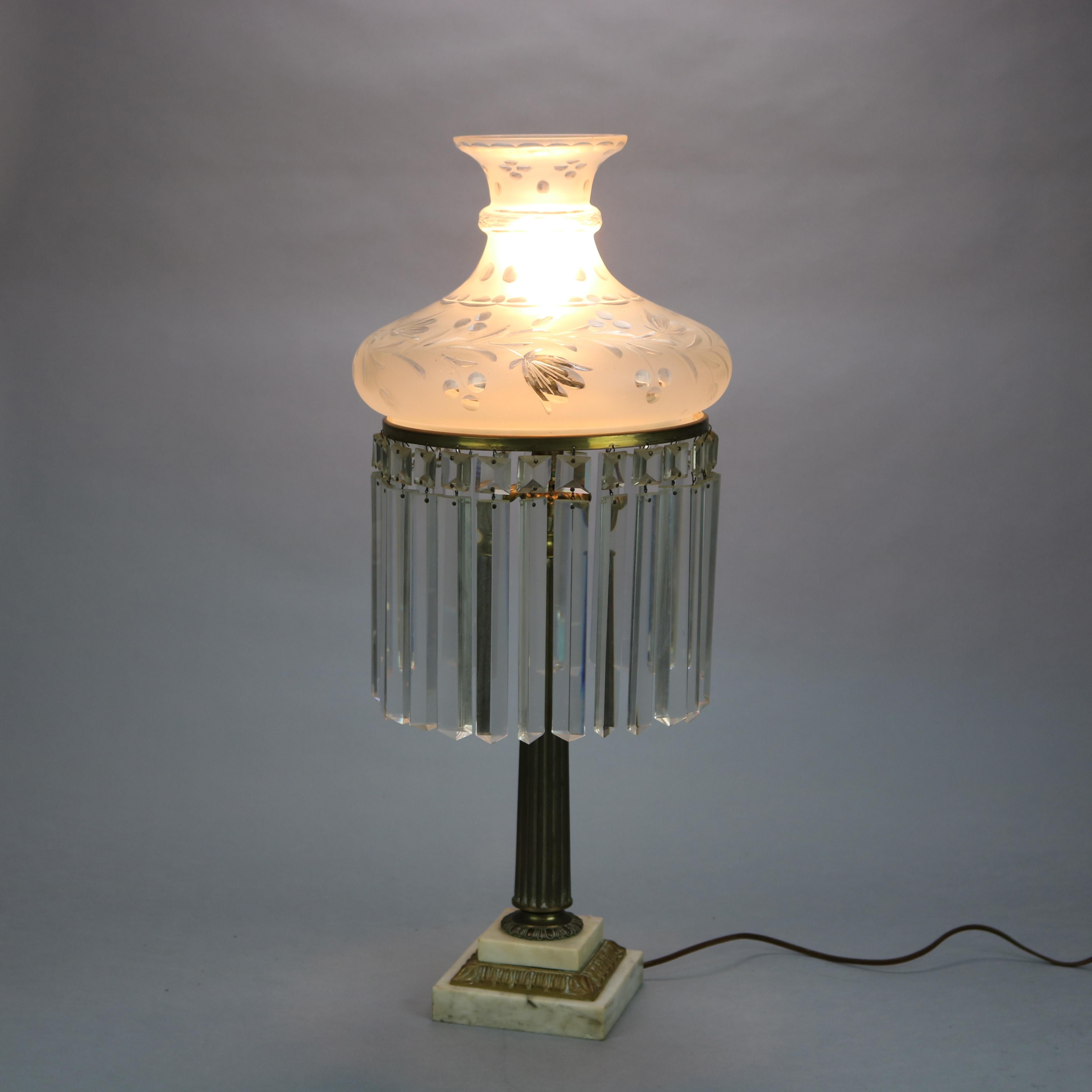 An antique electrified Neoclassical Sinumbra table lamp offers foliate cut glass shade over brass single socket base on stepped marble, hanging cut glass prisms surround, c1840.

Measures: 29.5