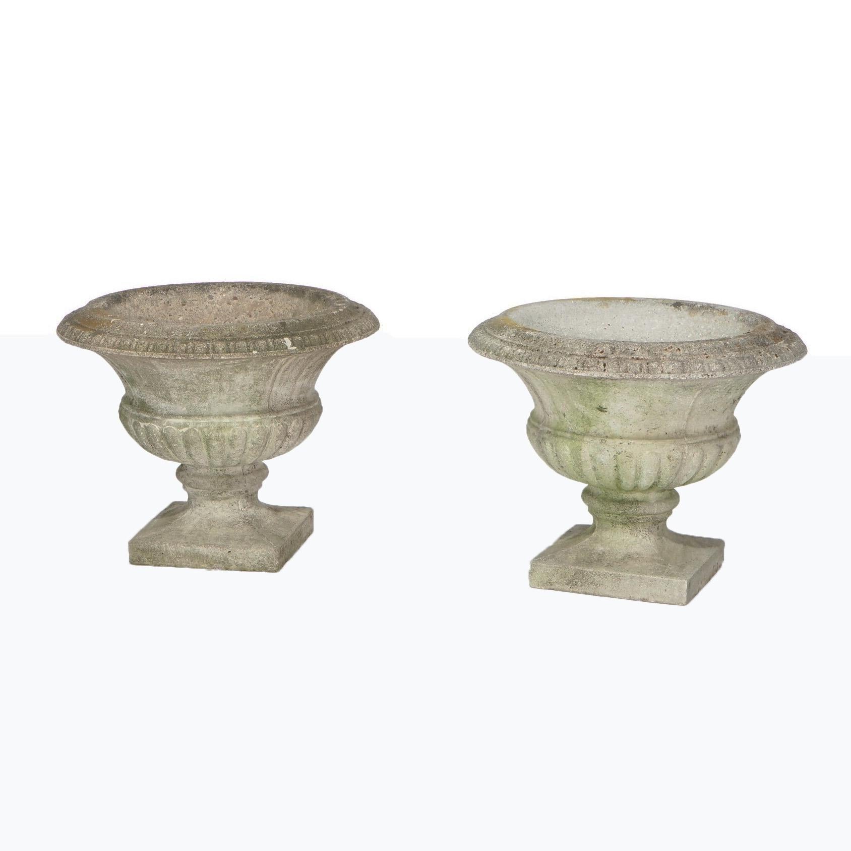 An antique pair of Neoclassical garden urn planters offers cast hardstone construction with gadroon rim and melon bowl, c1920.

Measures- 19.5''H x 24.5''W x 24.5''D.