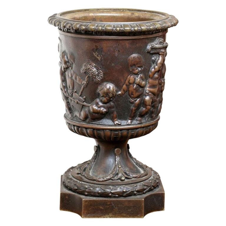 Antique Neoclassical Style Bronze Urn with Putti in Relief For Sale