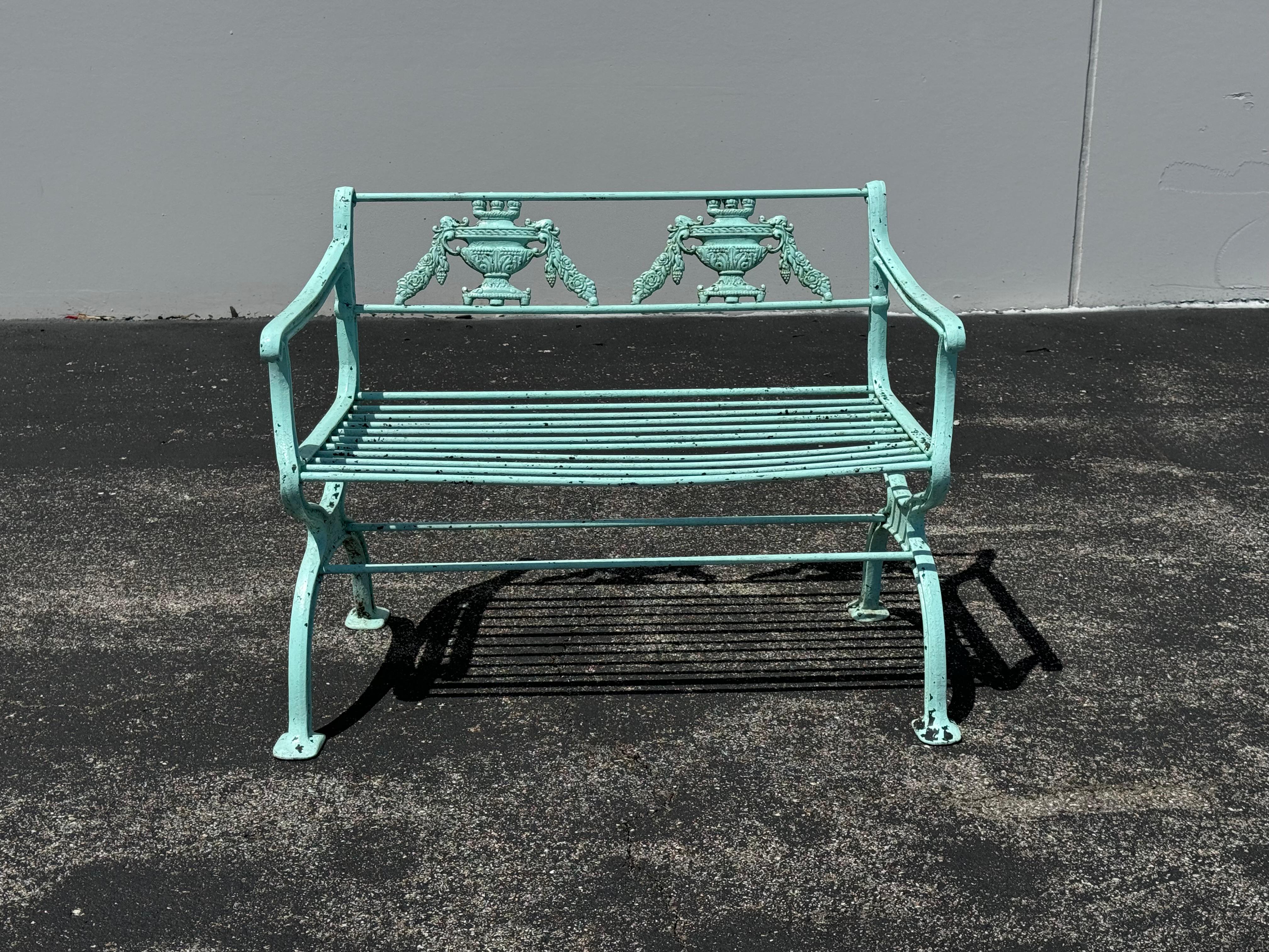 Antiguo banco o canapé de jardín de aluminio fundido de estilo Regencia o Neoclásico, pintado con un verde aguamarina muy fresco sobre pintura negra antigua que recuerda al bronce envejecido. Este banco está inspirado en un diseño de hacia 1835 del