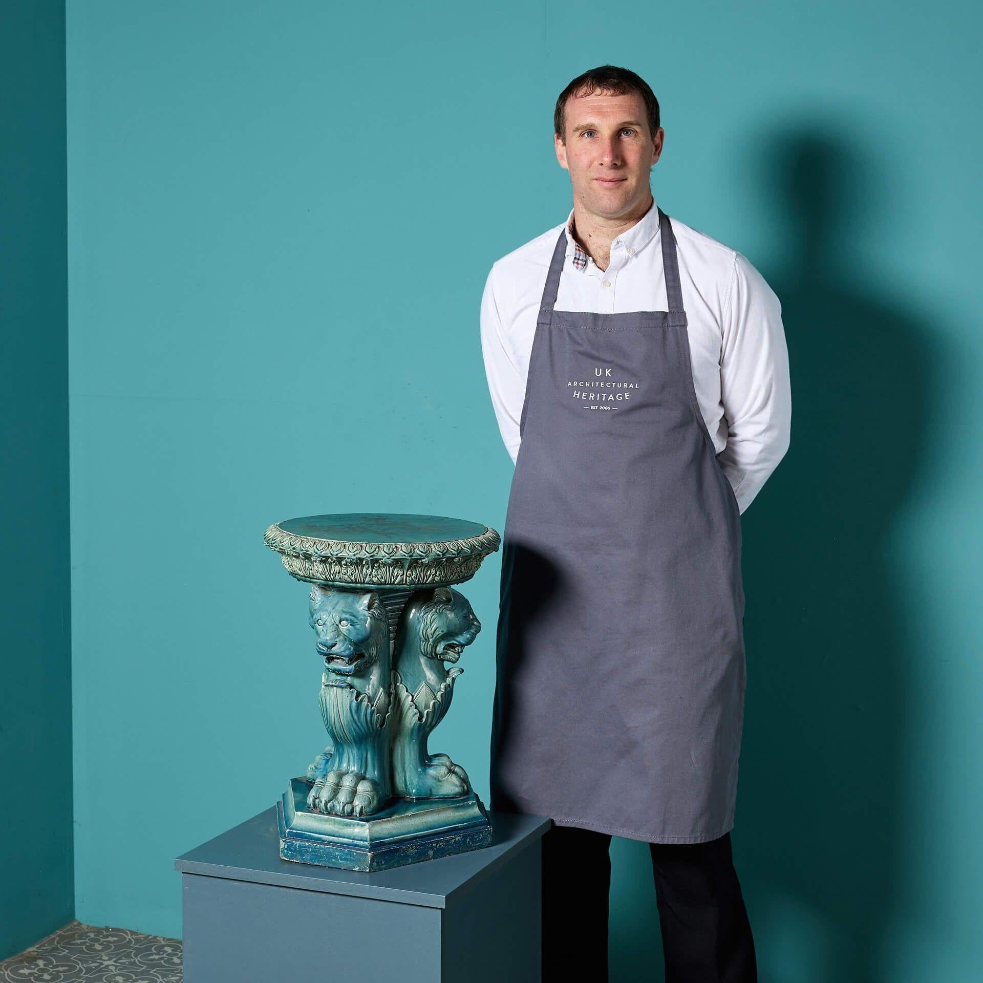 Antiker dreiflügeliger Ständer im neoklassizistischen Stil, glasiert und blau getönt, aus dem frühen 20.

Diese Skulptur zeigt ein einzigartiges Design von drei stilisierten Löwen mit beeindruckenden Pranken unter einer runden Platte auf einem