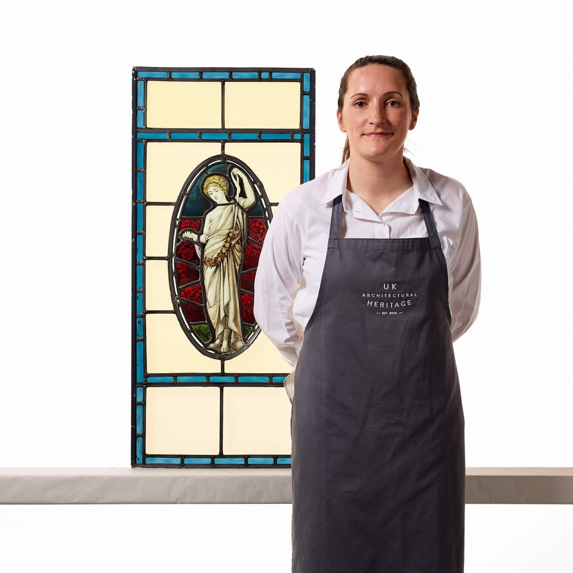 An elegant large neoclassical style stained glass window circa 1890. A Victorian take on a neoclassical design, this stained glass window centres around an elongated oval panel depicting a female dressed in white drapery, with flowers in her hair,