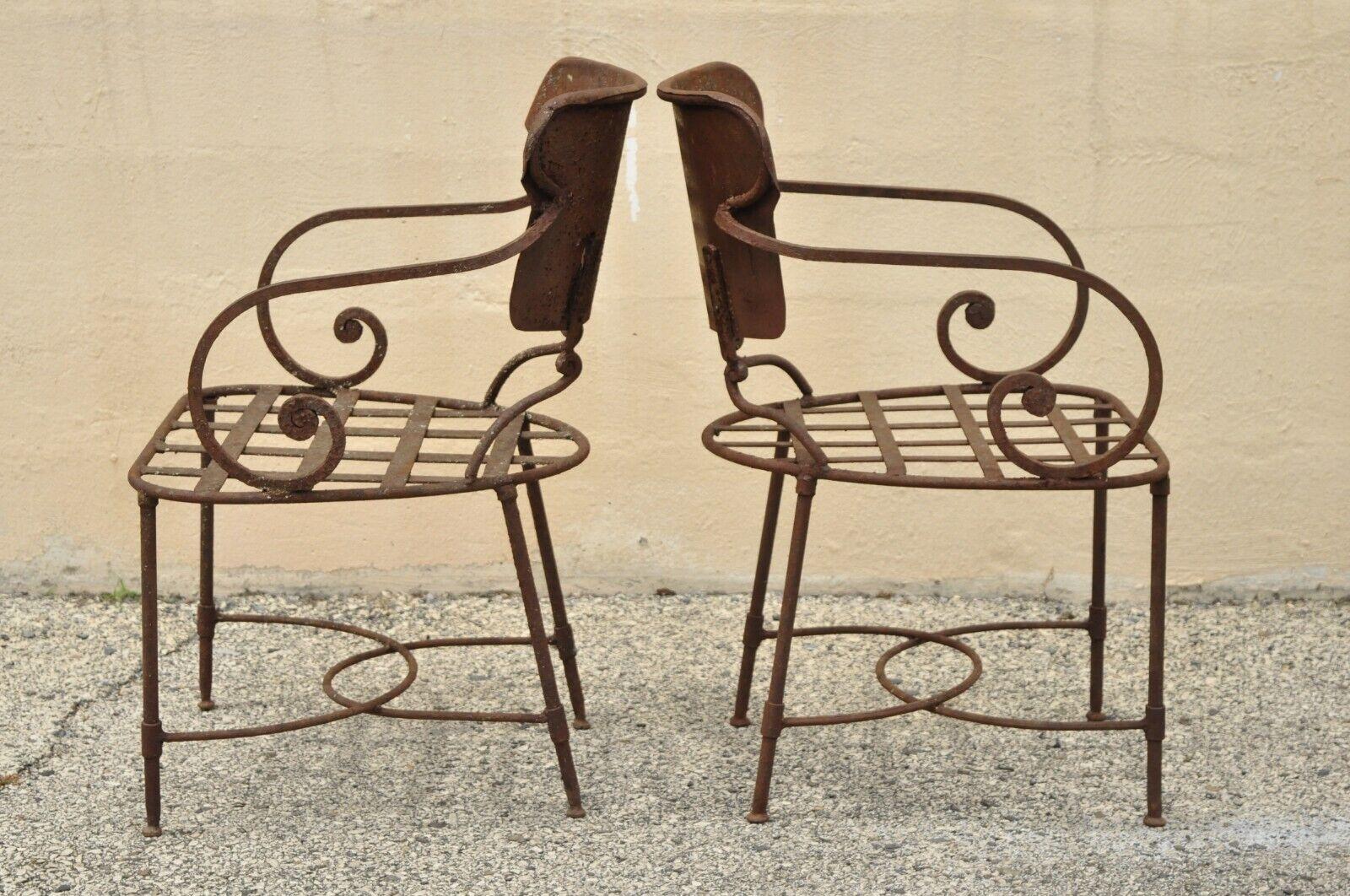 Antique Italian Neoclassical style wrought iron outdoor garden scrolling arm chairs - a pair. Item features heavy wrought iron metal frames, scrolling arms, stretcher base, quality craftsmanship, great style and form. Circa early to Mid 20th