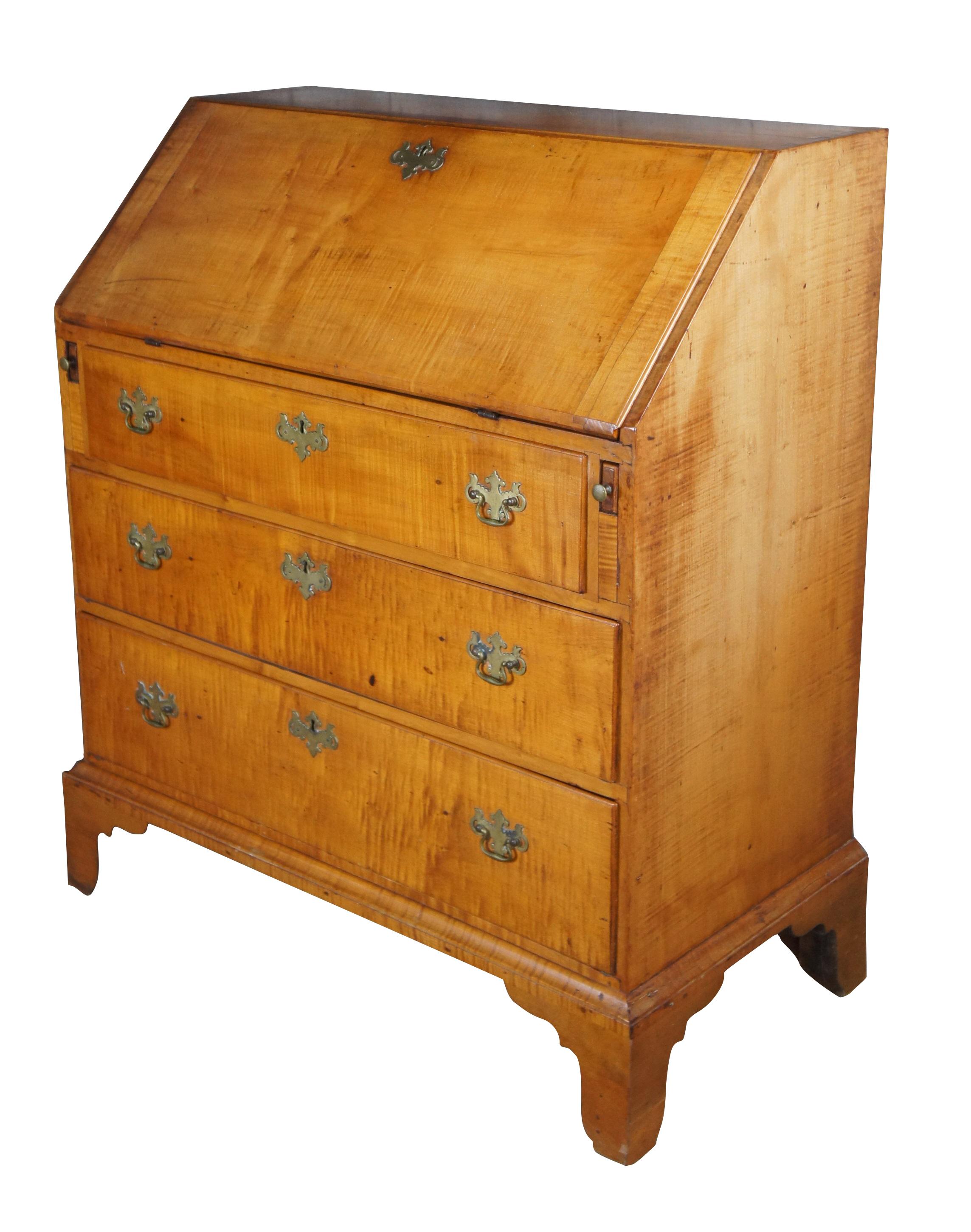 Un exquis bureau-secrétaire Chippendale de la Nouvelle-Angleterre, vers 1800. Le cadre est en érable ondé et les ferrures sont en laiton colonial. La façade s'ouvre sur une surface d'écriture, quatre tiroirs, six trous de pigeon et une porte de